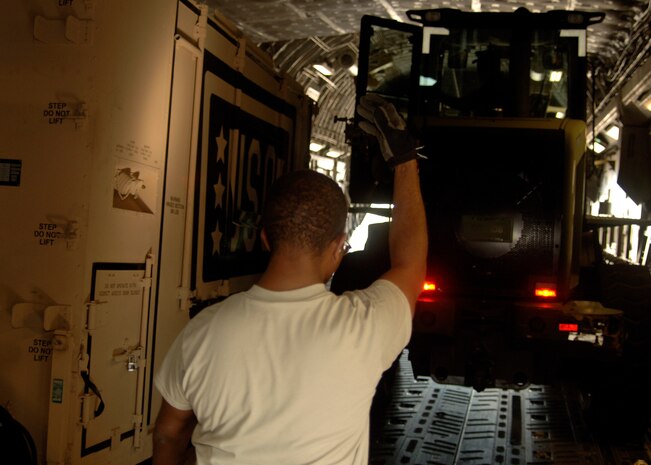 Senior Airman Raymond Banks guides a 10k all terrain forklift into the back of a Charleston C-17 to power the hydraulic lift system attached to the the USO cargo box here March 8. The USO delivers its programs and services to 1.4 million active duty service members and 1.2 million National Guard and Reserves as well as their families at more than 130 centers worldwide. Airman Banks is with the 437th Aerial Port Squadron. (U.S. Air Force photo/Senior Airman Timothy Taylor)