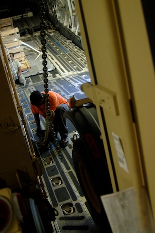 Corrie Frazier secures the last USO box to the floor of a Charleston C-17 before shipment here March 8. The USO ships packages downrange to troops throughout the year to help increase morale while they fight for their country. Mr. Frazier is with the 437th Aerial Port Squadron. (U.S. Air Force photo/Senior Airman Timothy Taylor)