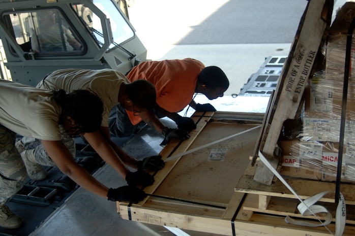 Airmen from the 437th Aerial Port Squadron push the last bit of USO cargo onto the back of a Charleston C-17 for shipment here March 8. The USO ships packages downrange to troops throughout the year to help increase morale while they fight for their country. (U.S. Air Force photo/Senior Airman Timothy Taylor) 