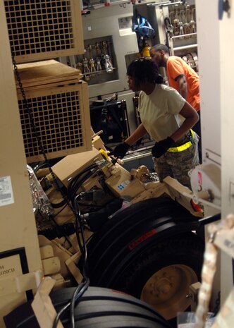 Senior Airman Veronica Garrison lowers the USO cargo onto the floor of a Charleston C-17 using the new hydraulic lift system attached to the cargo here, March 8. The USO ships packages downrange to troops throughout the year to help increase morale while they fight for their country. Airman Garrison is with the 437th Aerial Port Squadron. (U.S. Air Force photo/Senior Airman Timothy Taylor)