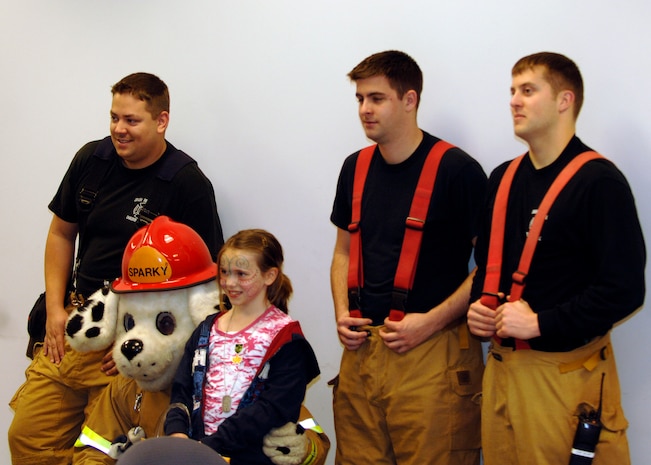 Sparky the fire dog and Charleston firemen pose for photos during the children's deployment line here March 7. The children's deployment line is a program developed to help show children what their parents go through before they deploy downrange. (U.S. Air Force photo/Senior Airman Timothy Taylor)