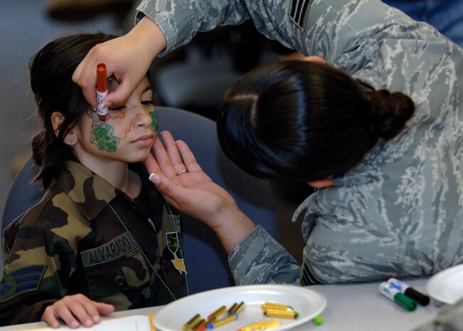 Zayra Alvarado gets her face painted at the children's deployment line here March 7. The children's deployment line is a program developed to help show children what their parents go through before they deploy downrange. Zayra is the 7-year-old daughter of Tech. Sgt. Angel Alvarado Rivera, assigned to the 437th Communications Squadron. (U.S. Air Force photo/Senior Airman Timothy Taylor)

