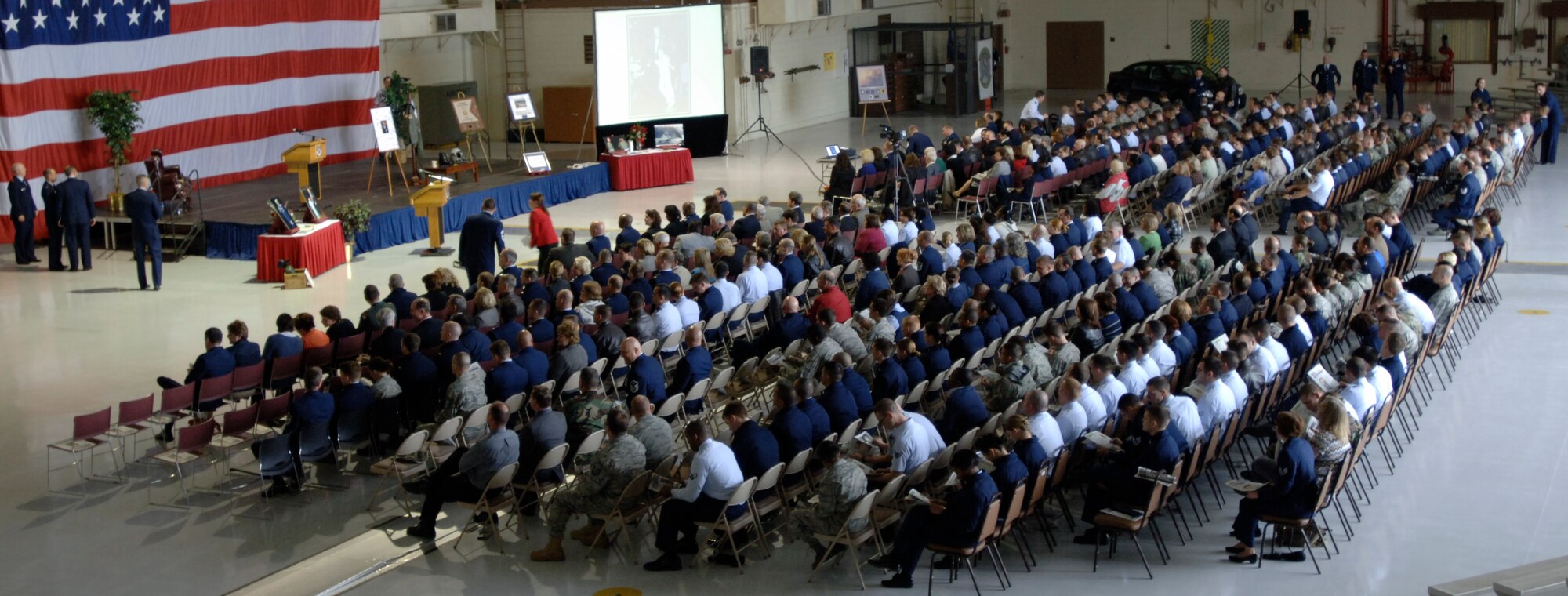 MCCONNELL AIR FORCE BASE, Kan. -- Team McConnell members are seated in hangar 1176 during the memorial service for Col. Michael V. Krueger, March 9. Some of Colonel Krueger’s memorabilia and photos were on display for wing members to see along with a book for guests to sign. (Photo by Senior Airman Laura Suttles)