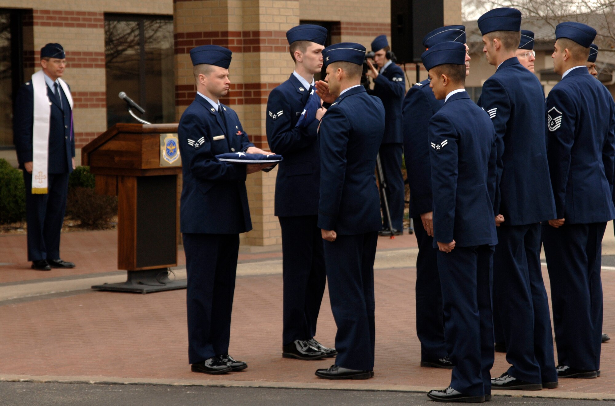 MCCONNELL AIR FORCE BASE, Kan. -- Col. James C. Vechery, 22nd Air Refueling Wing commander salutes an American flag held by Senior Airman Daniel Mills, 22nd ARW, during Col. Michael V. Krueger’s retreat ceremony held outside building 1, March 9. Colonel Krueger was the 22nd ARW vice commander. (Photo by Senior Airman Laura Suttles) 