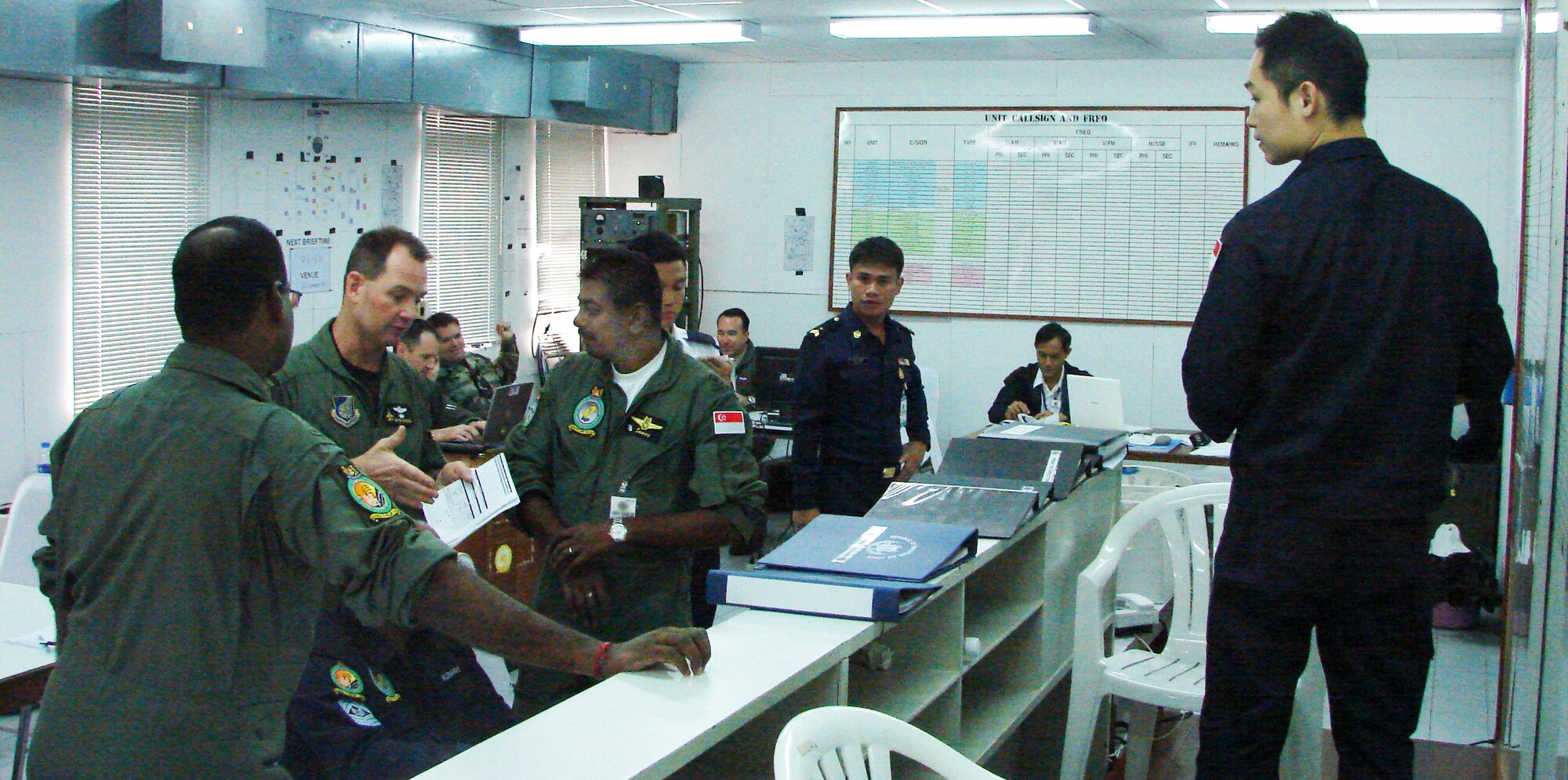 U.S. and Republic of Singapore Air Force personnel discuss the flying schedule March 11 in the Cope Tiger 2009 live fly cell at Korat Royal Thai Air Force Base, Thailand.  Cope Tiger is an annual, multilateral large force aerial exercise conducted in Thailand including U.S., Thai and Singaporean military forces.  The two-week exercise includes both aerial and humanitarian events.  (U.S. Air Force photo/Capt. Erika Yepsen)