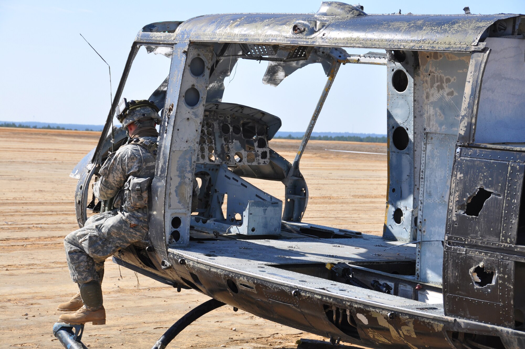 A solider from the 82nd Airborne Division mans his radio from a shelled-out helicopter during a Joint Forcible Entry Exercise at Fort Bragg, N.C., March 2-8. During the exercise, Airmen from the 621st Contingency Response Wing and Soldiers from the 689th Rapid Port Opening Element conducted an airfield assessment and exercised the Joint Task Force - Port Opening mission after the Army seized the airfield. (U.S. Air Force photo/1st Lt. Dustin Doyle)