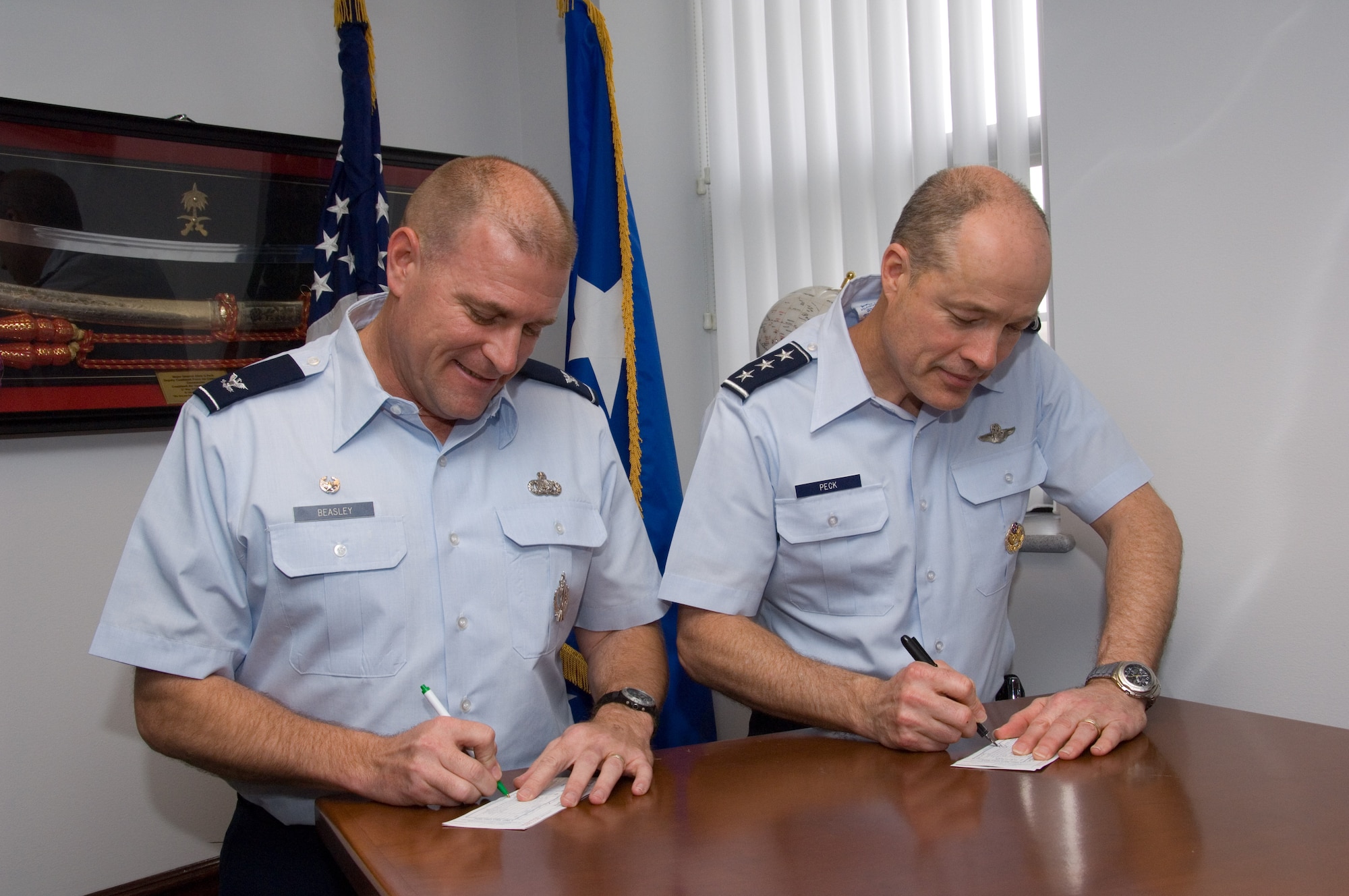 Lt. Gen. Allen G. Peck (right), commander of Air University, and Col. Kris D. Beasley, commander of the 42nd Air Base Wing, sign their pledge cards for the 2009 Air Force Assistance Fund campaign in the general's office March 9. According to project officer Capt. Benjamin Henley, a goal of $72,031 has been set for Maxwell-Gunter in the campaign ending April 5. The fund benefits organizations that help Air Force people with aid in an emergency, with educational needs, or to have a secure retirement home for Air Force widows or widowers. Active-duty Airmen and retirees may elect payroll deductions, but cash and money orders are also accepted. (Air Force photo by Melanie Rodgers Cox)