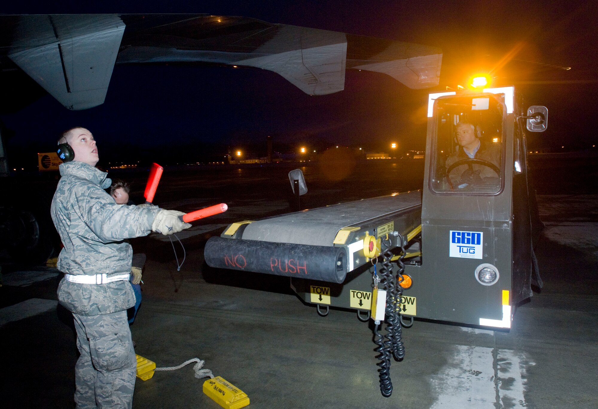 ELMENDORF AIR FORCE BASE, Alaska -- Senior Airman Trenton Barber, 732nd Air Mobility Squadron, guides a conveyor belt to load equipment from 4th Brigade, 25th Infantry Division (Airborne), heading to Afghanistan March 10, 2009. The 4th BDE 25th ID is deploying 3,500 soldiers to perform counter-terrorism operations, aid with reconstruction, and educate and equip the Afghan national security forces. (U.S. Air Force photo/Senior Airman Jonathan Steffen)