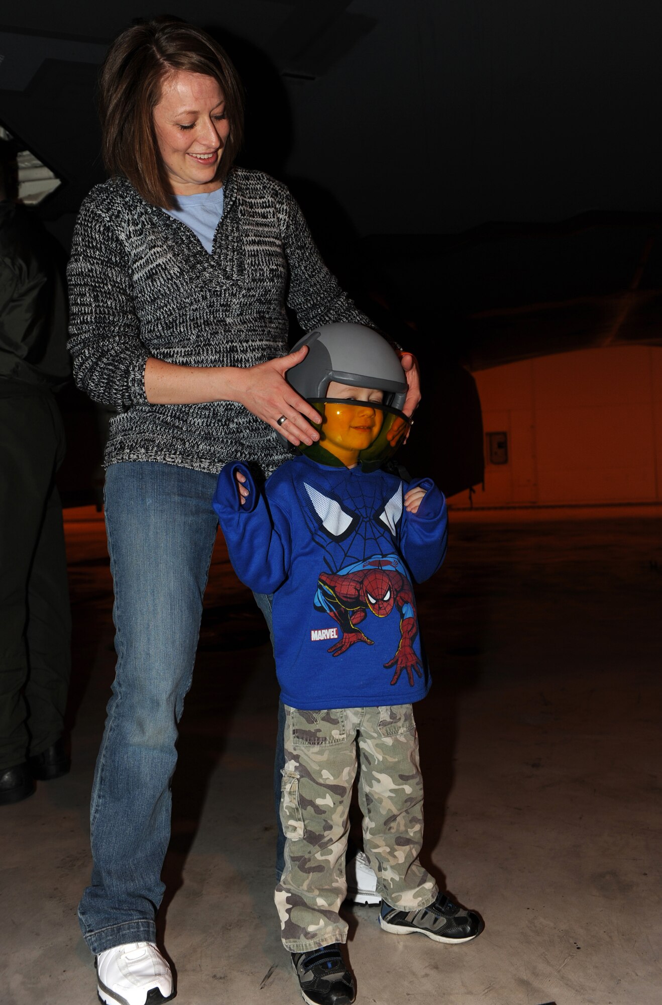 WHITEMAN AIR FORCE BASE, Mo. – Jill Bolling adjusts a pilot’s helmet on her son, Kellen Bolling during his day as a pilot here Feb. 27. During the day, Kellen participated in A-10 and B-2 tours, had lunch at the club with several Whiteman pilots and flew the A-10 and B-2 simulator. (U.S. Air Force photo/Airman 1st Class Carlin Leslie)