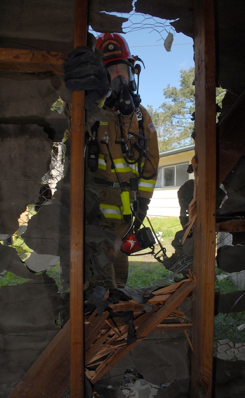 VANDENBERG AIR FORCE BASE, Calif.-- Manny Villegas, a 30th Civil Engineer Squadron firefighter, enters through a wall after a forceable entry exercise March 5 in East Housing here.  Vandenberg's firefighters went through the training to prepare for possible future rescue situations. (U.S. Air Force photo/Airman 1st Class Antoinette Lyons)
