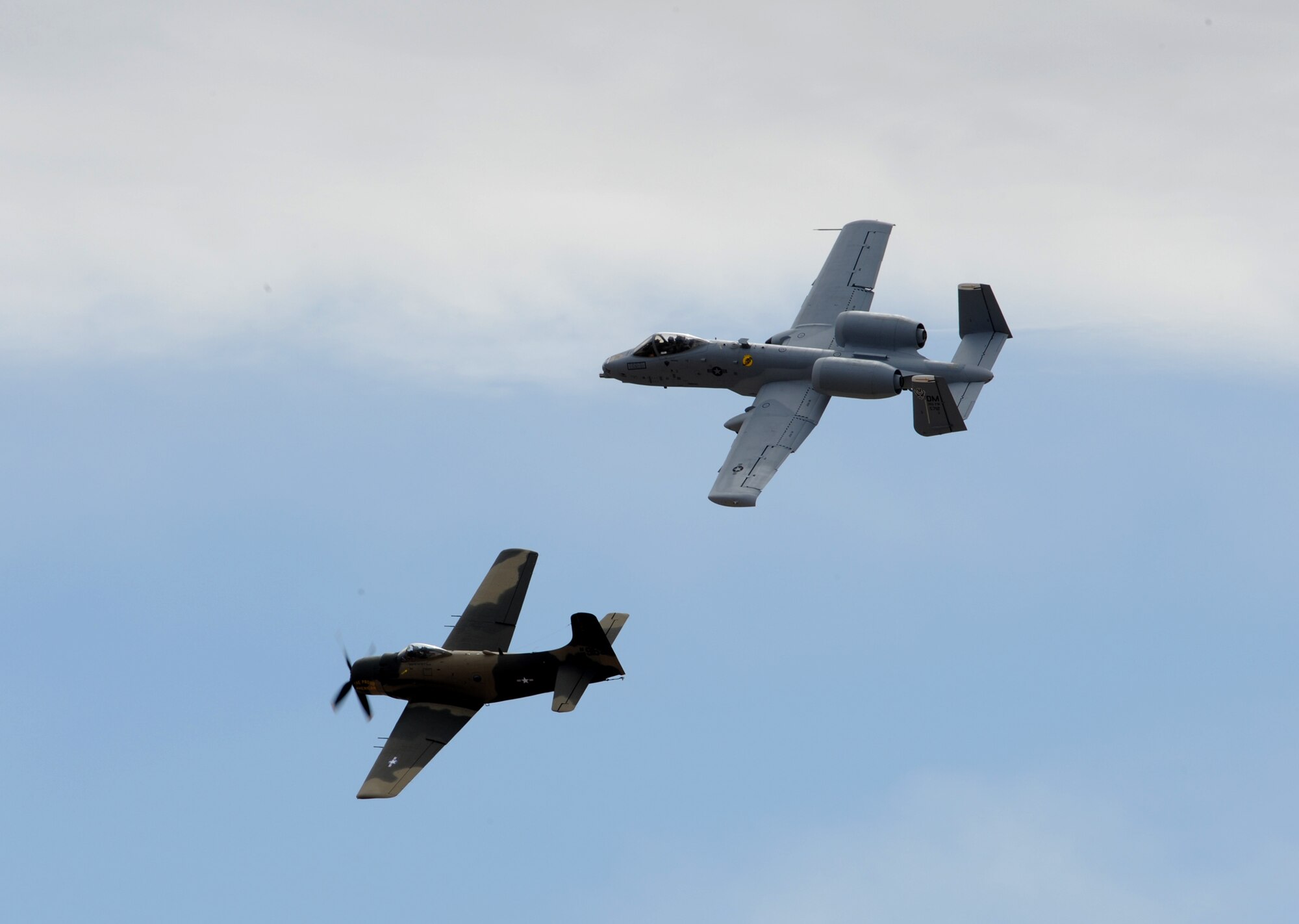 An A-10 Thunderbolt II (top) flies in formation with an A-1 Skyraider at the Heritage Flight Conference here March 7. The Skyraider, which was employed in combat in Vietnam and Korea, is one of the A-10's attack aircraft predecessors. (U.S. Air Force photo/Staff Sgt. Valerie Smith)