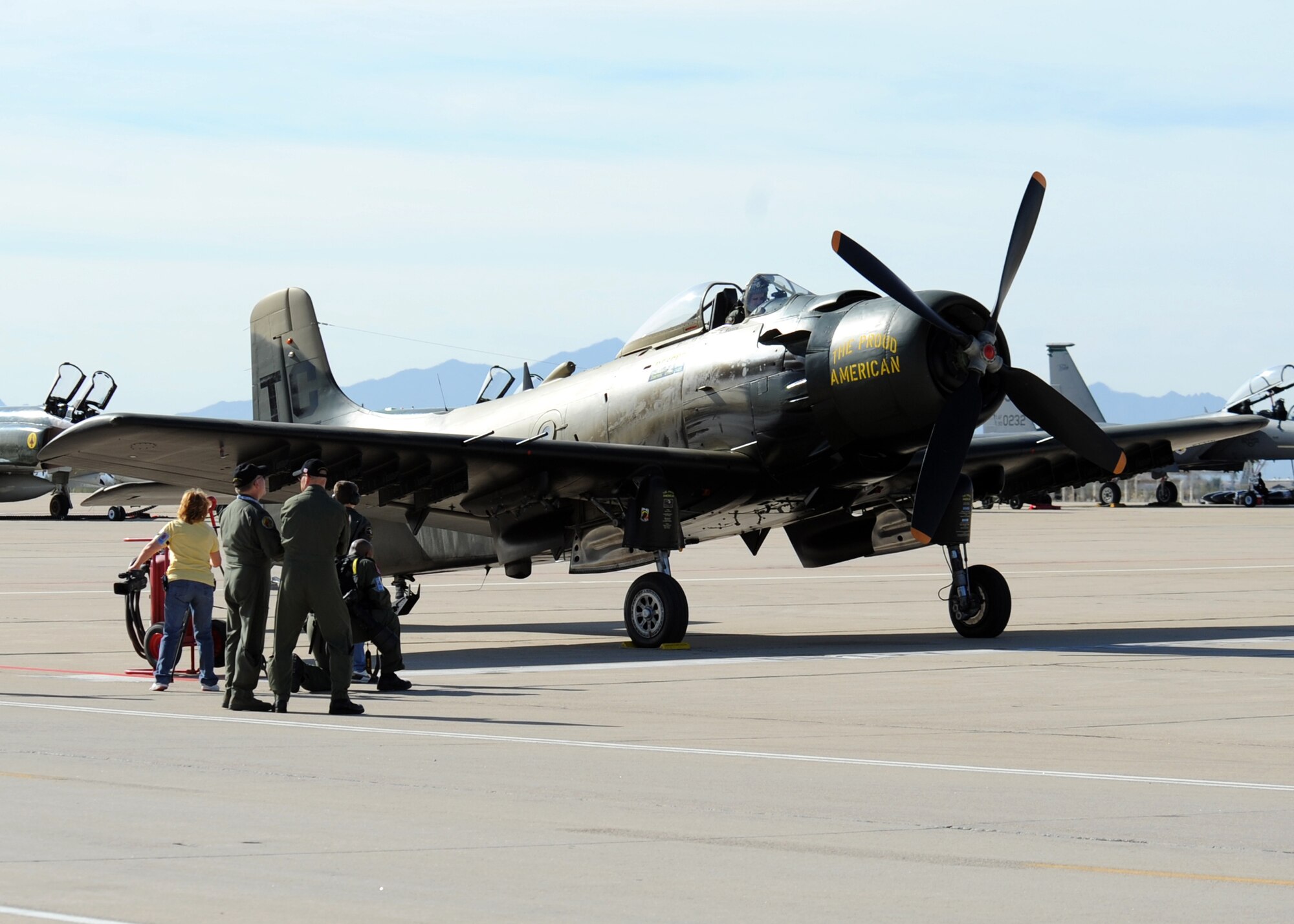 Onlookers wait while a pilot prepares to start the engine of his A-1 Skyraider before a practice demonstration flight at the Heritage Flight Conference here March 7. The Skyraider was an attack bomber employed during the Vietnam and Korean wars, and it was part of the inspiration for the A-10 Thunderbolt II. (U.S. Air Force photo/Airman 1st Class Brittany Dowdle)