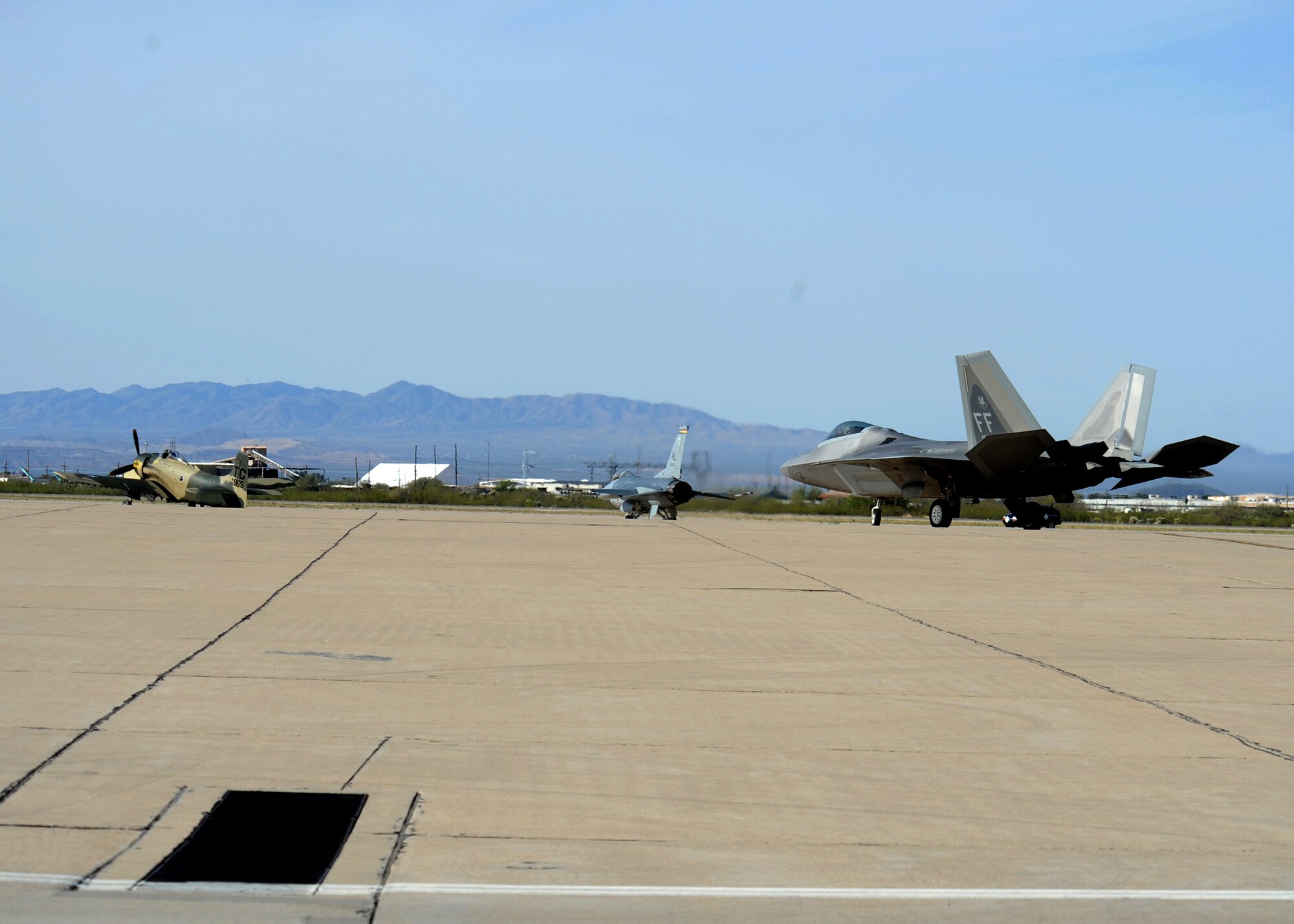 An A-1 Skyraider (left), F-16 Fighting Falcon (middle) and F-22 Raptor taxi out to the runway before taking off to practice formation flights at the Heritage Flight Conference here March 7. (U.S. Air Force photo/Airman 1st Class Brittany Dowdle)