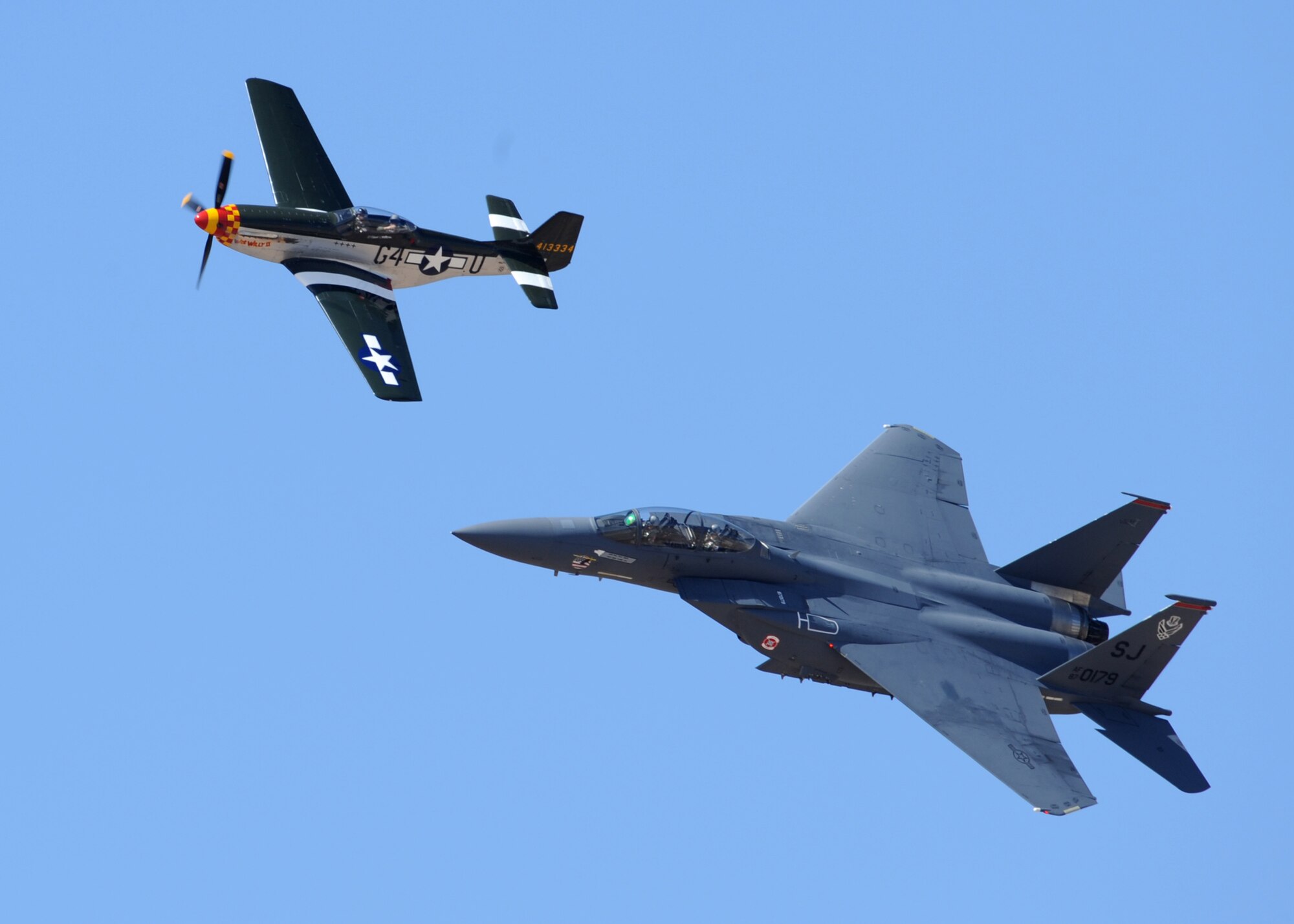 A P-51 Mustang (top) and F-15 Eagle fly in formation during the Heritage Flight Conference here March 7. Pilots of old and new aircraft come to the HFC every year to practice demonstration flights together before the air show season. (U.S. Air Force photo/Senior Airman Noah R. Johnson)