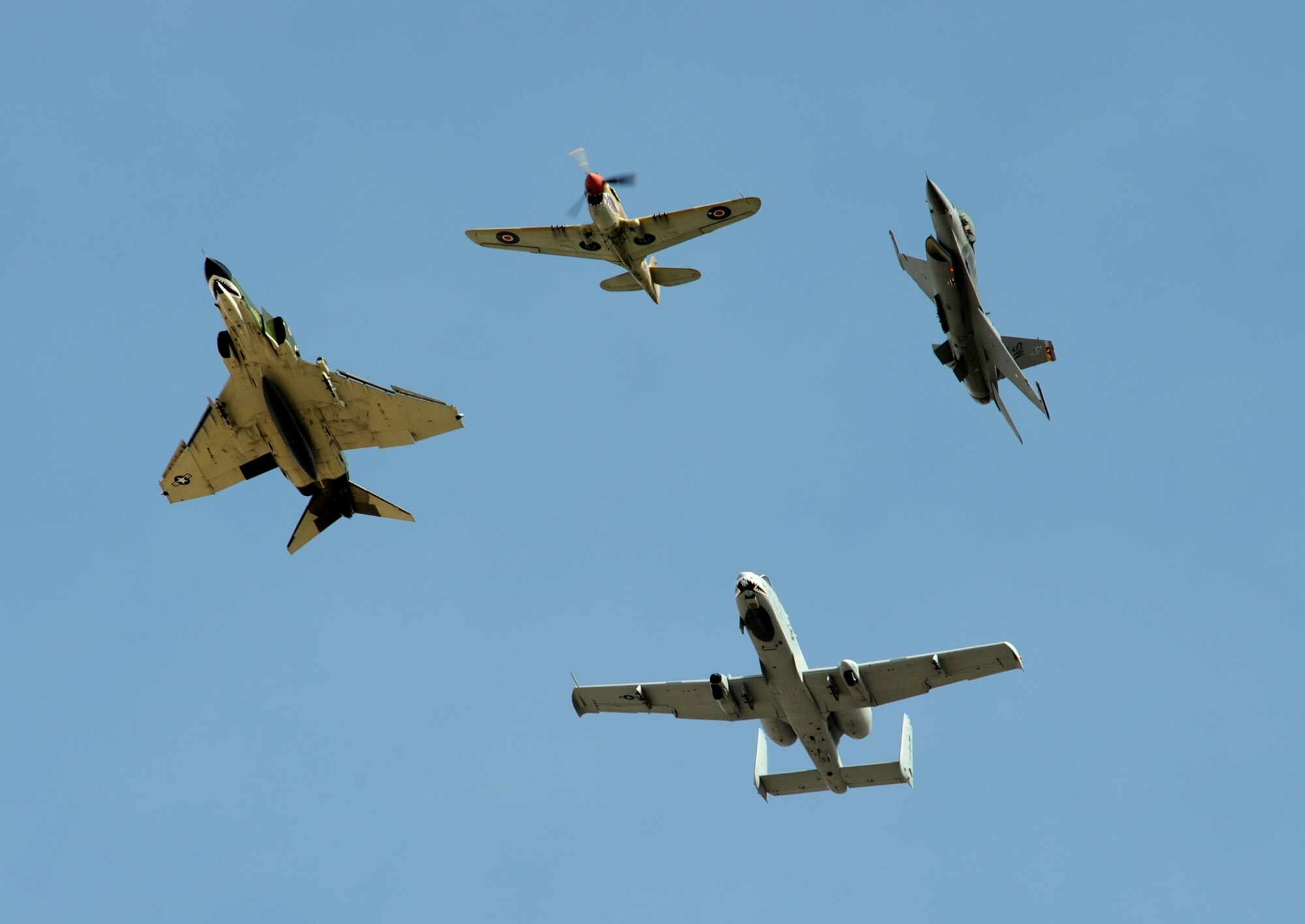 An F-4 Phantom (left), P-40 Warhawk (top), F-16 Fighting Falcon (right) and A-10 Thunderbolt II fly in formation during the Heritage Flight Conference here March 7. Pilots of old and new aircraft come to the HFC every year to practice demonstration flights together before the air show season. (U.S. Air Force photo/Staff Sgt. Valerie Smith)