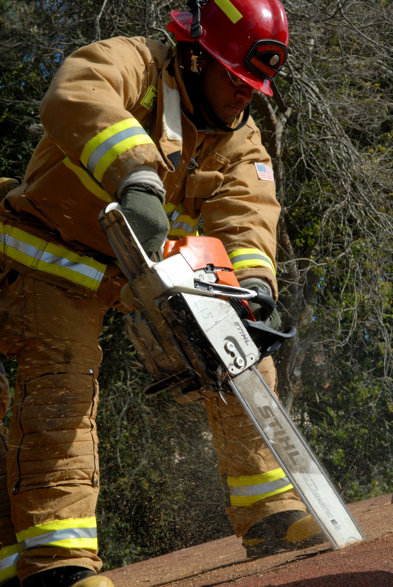 VANDENBERG AIR FORCE BASE, Calif.-- Staff Sgt. CiJi Brown, a 30th Civil Engineer Squadron firefighter, uses a saw to cut a sqaure on the roof of a condemned home during a vertical ventilation exercise March 5 in East Housing here. Vandenberg's firefighters went through the training to prepare for possible future rescue situations.  (U.S.Air Force photo/Airman 1st Class Antoinette Lyons)