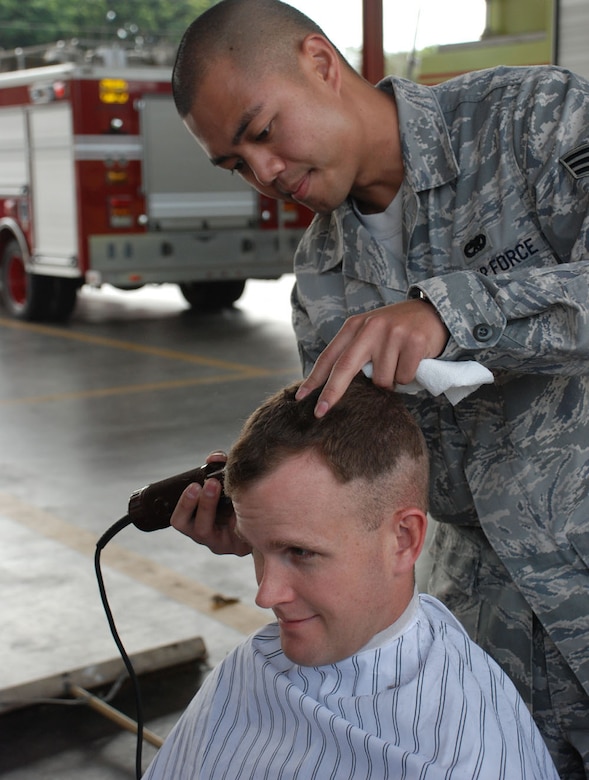 SOTO CANO AIR BASE, Honduras -- Senior Airman Bryan Trinidad, 612th Air Base Squadron, shaves Capt. William Notbohm's head to raise money for children's cancer research through the St. Baldrick's Foundation.  Capt. Nothohm is the base civil engineer.  The Soto Cano Fire Department raised more than $2,500 by holding a head-shaving event here March 6.  Spnsored by family and friends, volunteers went bald in solidarity with kids who typically lose their hair during cancer treatment.  (U.S. Air Force photo/Tech. Sgt. Rebecca Danét)
 