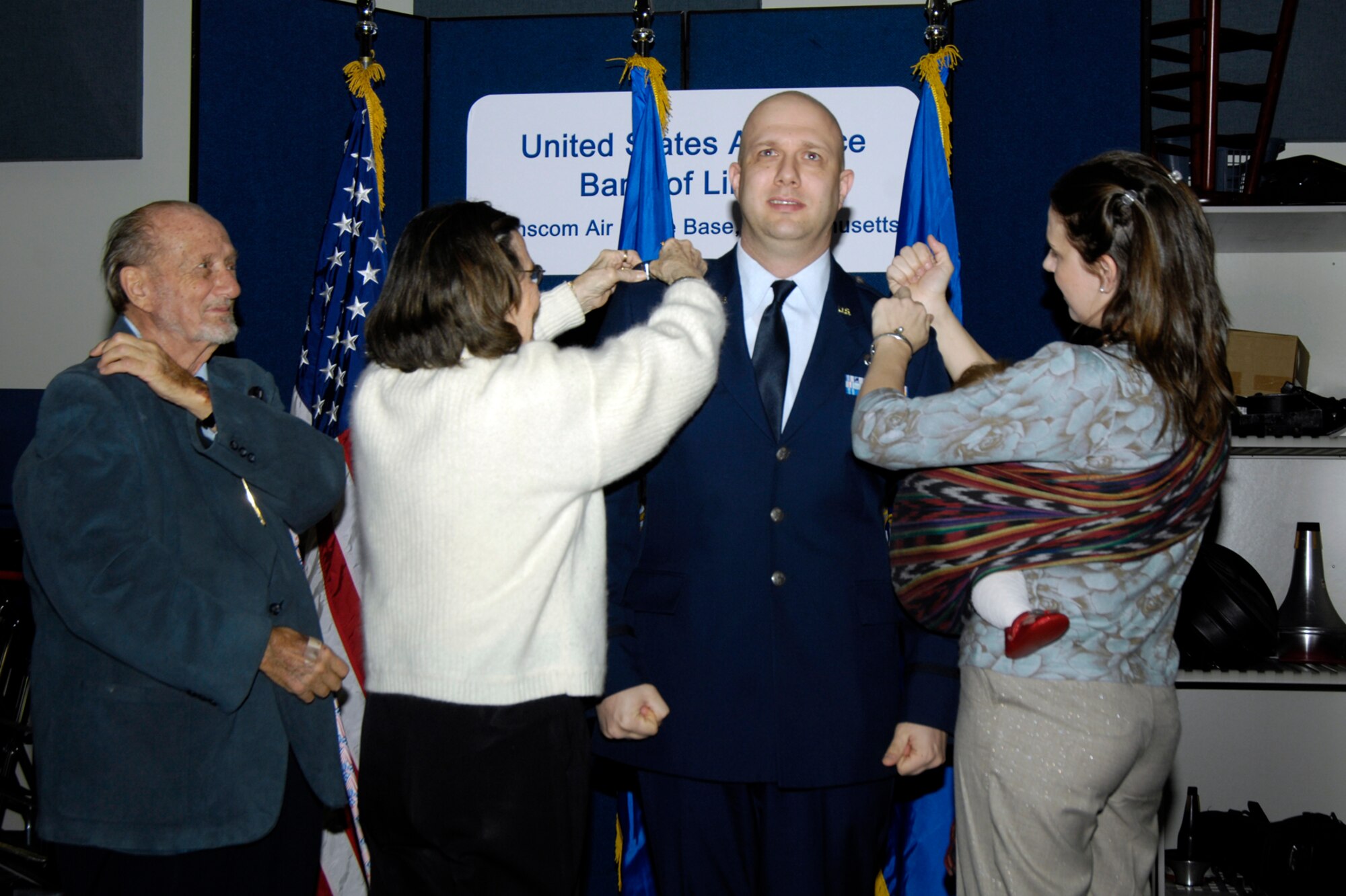 Captain David A. Alpar gets his new bars the old fashion way!  His father, mother, and wife were present for the ceremony.
