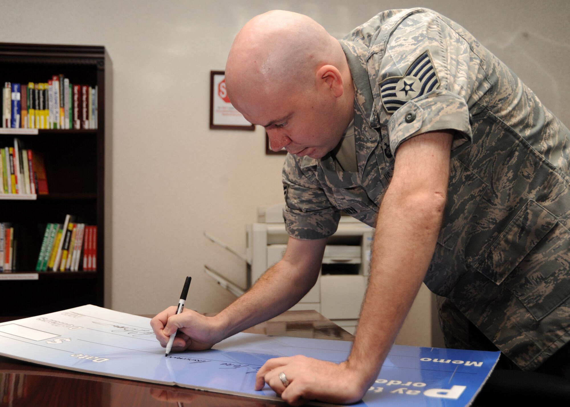 SCOTT AIR FORCE BASE, Ill. --Tech. Sgt. Robert Brown, 375th Mission Support Squadron, gets an early start on check signing for the Air Force Assistance Fund.  The AFAF begins Monday to raise funds to support Airmen who are experiencing financial hardships. (U.S. Air Force photo/Airman 1st Class Wesley Farnsworth) 