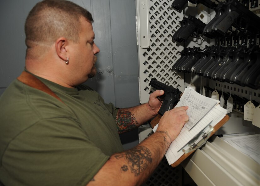 SCOTT AIR FORCE BASE, Ill. --Rod Hampton, War Readiness Element material coordinator, inspects a M-9 Berettas for the proper serial number before issuing to a customer. (U.S. Air Force photo/Staff Sgt. Paul Villanueva)