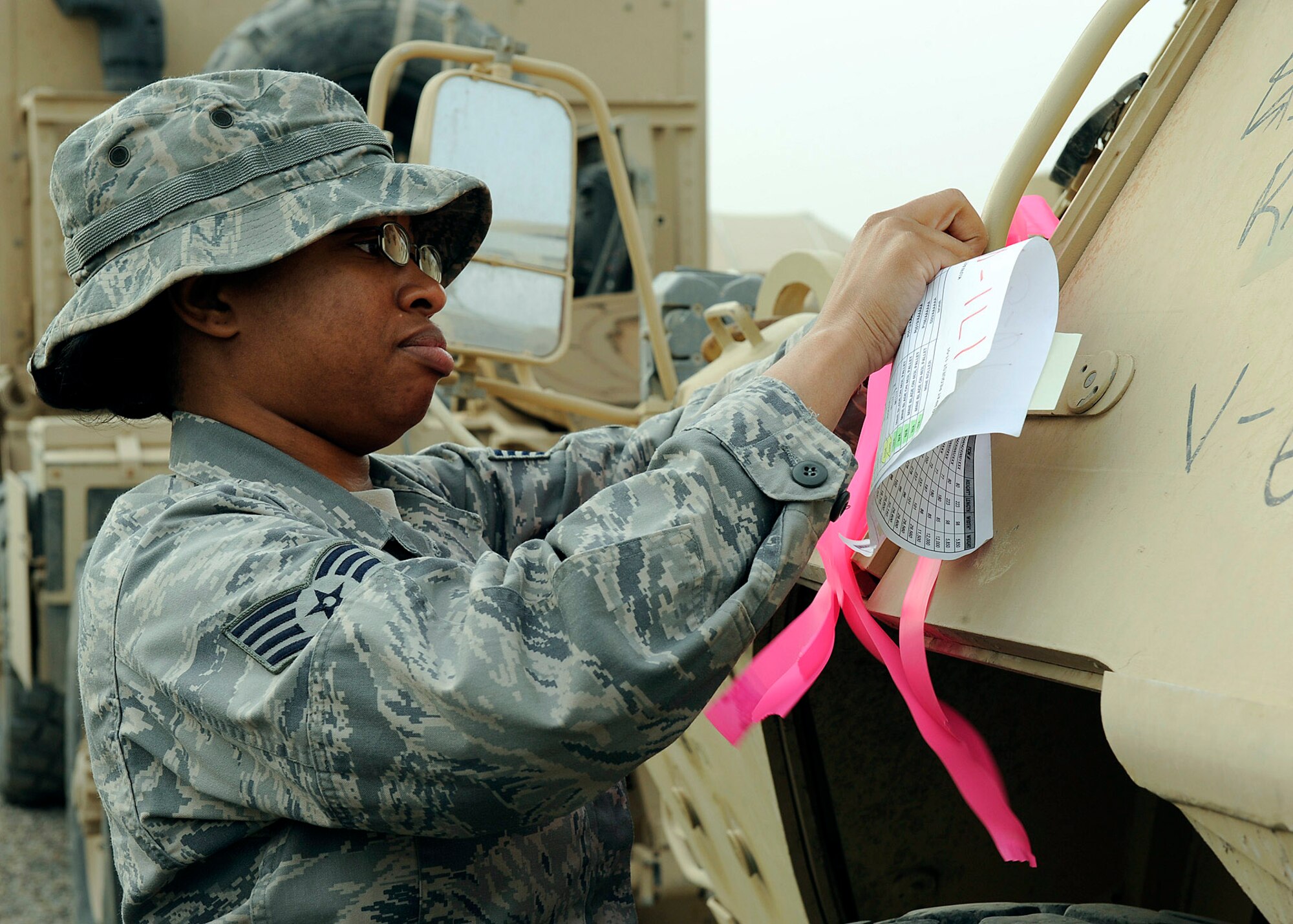 Staff Sgt. Chayla Gooch marks the armored security vehicle ensuring the right vehicles get picked up for transport Feb. 27 at Camp Liberty, Iraq. This vehicle is a part of a convoy going to Kuwait with approximately 30 semitrucks loaded with all types of military vehicles. Sergeant Gooch is assigned to the 732nd Expeditionary Logistical Readiness Squadron, 586th Task Force. She is a native of Marksville, La., and is deployed from Langley Air Force Base, Va. (U.S. Air Force photo/Senior Airman Jacqueline Romero) 

