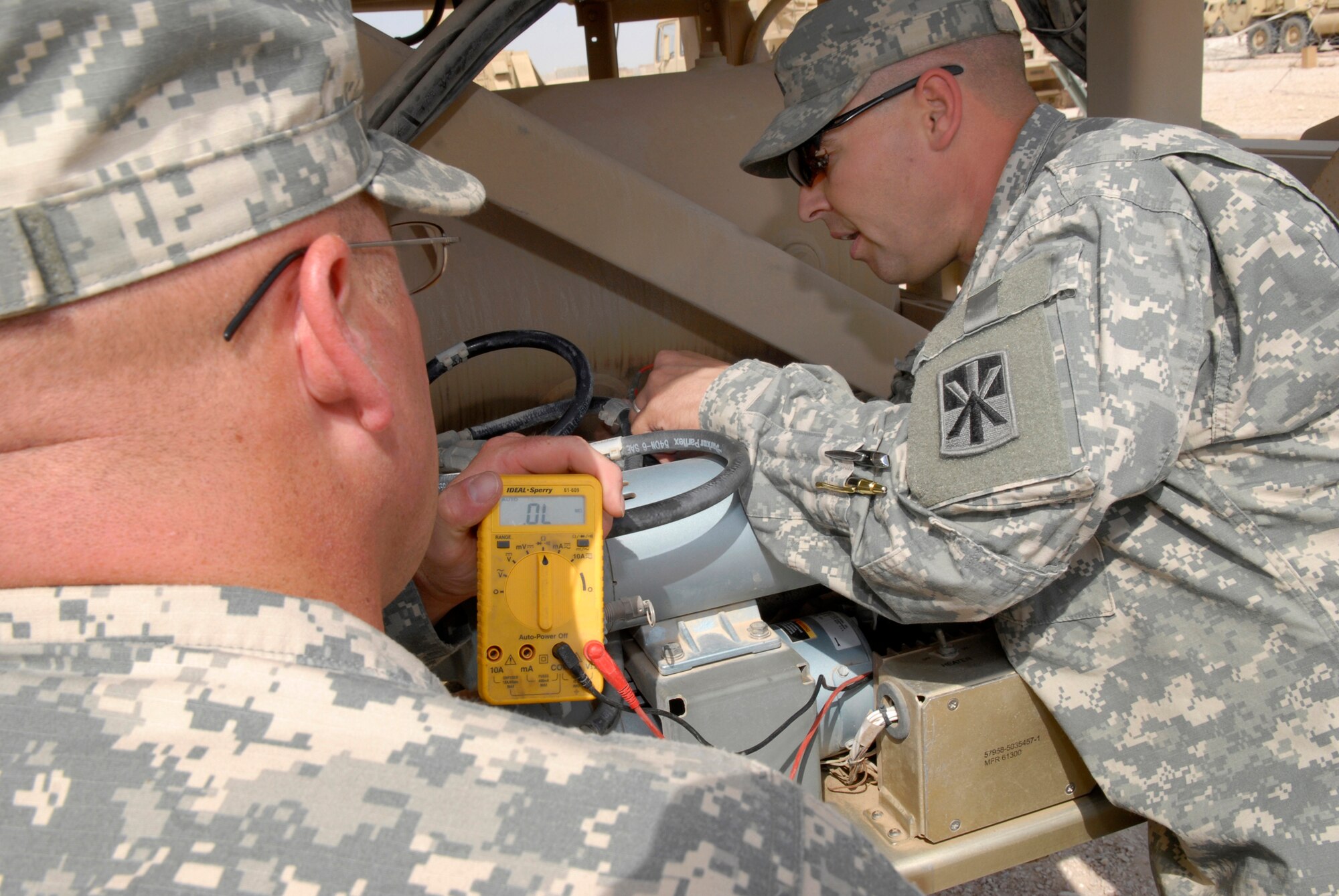 U.S. Army Spc. Toby Tennyson and Sgt. Henry Tye, 2-43 Air Defense Artillery Battalion technicians, check the air compressor motor which allows a radar antenna to rise, supporting constant communication capability for the patriot missiles, Mar. 10, 2009, at an undisclosed location in Southwest Asia.  Specialist Tennyson hails from Kaysville, Utah and Sergeant Tye hails from Tahlaquah, Okla.  Both are deployed from Fort Bliss, Texas in support of Operations Iraqi and Enduring Freedom and Combined Joint Task Force - Horn of Africa.  (U.S. Air Force Photo by Senior Airman Andrew Satran/Released)