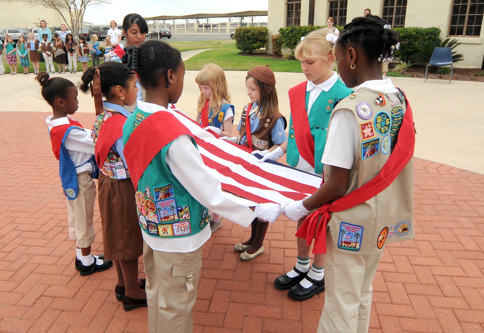 Randolph Girl Scout troops fold the flag during a ceremony outside Gaylor Airman Leadership School March 10. (U.S. Air Force photo by Steve White)