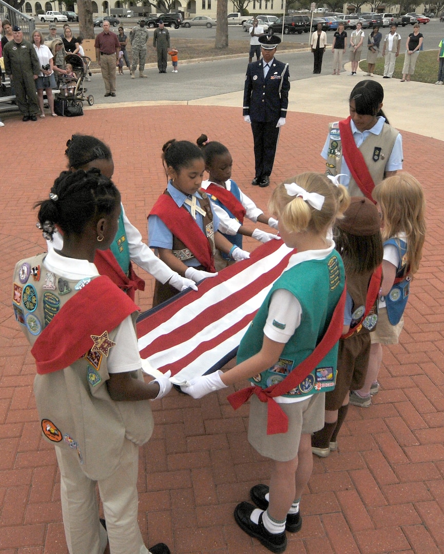 Randolph Girl Scout troops fold the flag during a ceremony outside Gaylor Airman Leadership School March 10. (U.S. Air Force photo by Steve White)