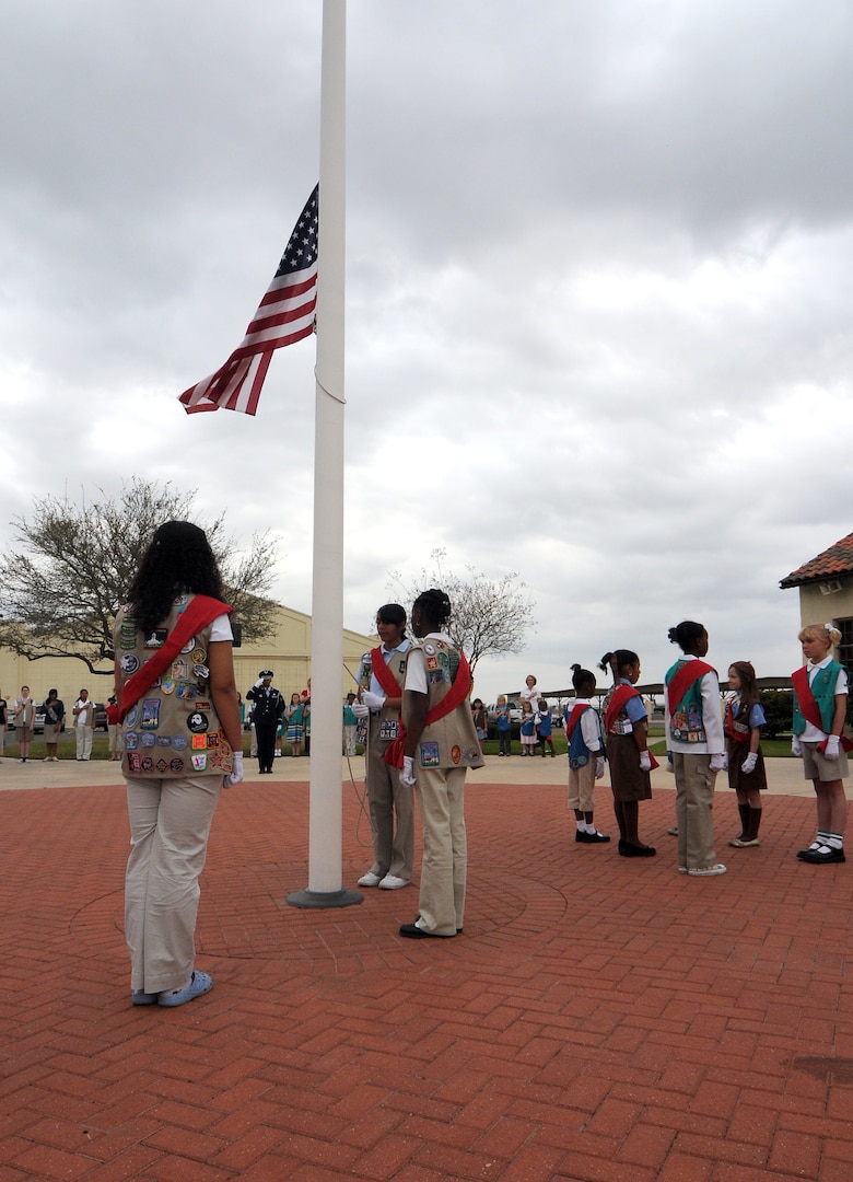 Randolph Girl Scout troops raise the flag during a ceremony outside Gaylor Airman Leadership School March 10. (U.S. Air Force photo by Steve White)
