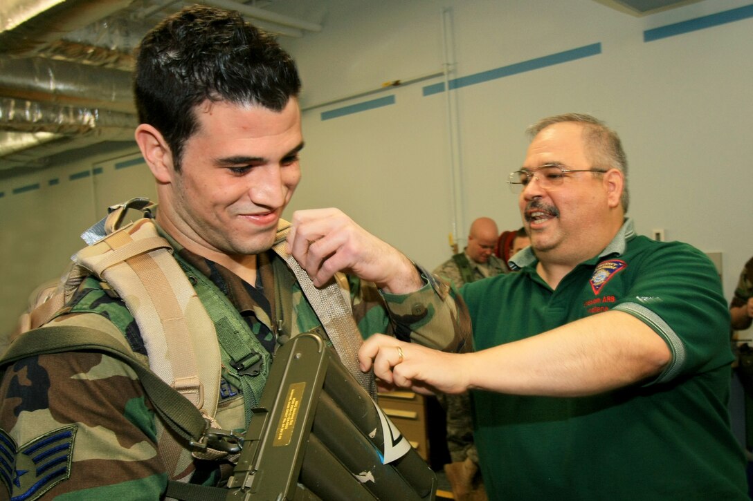 GRISSOM AIR RESERVE BASE, Ind., -- Staff Sgt. Nick Delaurentis, fitness specialist with the 434th Services Squadron, is instructed on how to wear post attack recovery and identification kits by Robert Wydock, an emergency management technician with the 434th Civil Engineer Squadron.  The instruction was part of a training class held during a recent unit training assembly.  (U.S. Air Force Photo/TSgt. Patrick Kuminecz)