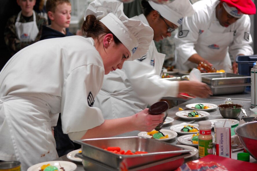 MINOT AIR FORCE BASE, N.D. --  Senior Airman Natasha Mathews, Airman 1st Class Qushondra Owens, and Staff Sgt. Cory Upshaw, Chefs from the 5th Force Support Squadron, dress their pistachio chocolate puddings during the 2009 Warrior Chef Challenge here, March 5. The Warrior Chef Challenge is a competition where two teams battle head-to-head and see who can prepare the best meal without knowing the actual ingredients. This has been the first year that the 5th Bomb Wing has participated in the challenge. (U.S. Air Force photo by Senior Airman Joe Rivera)