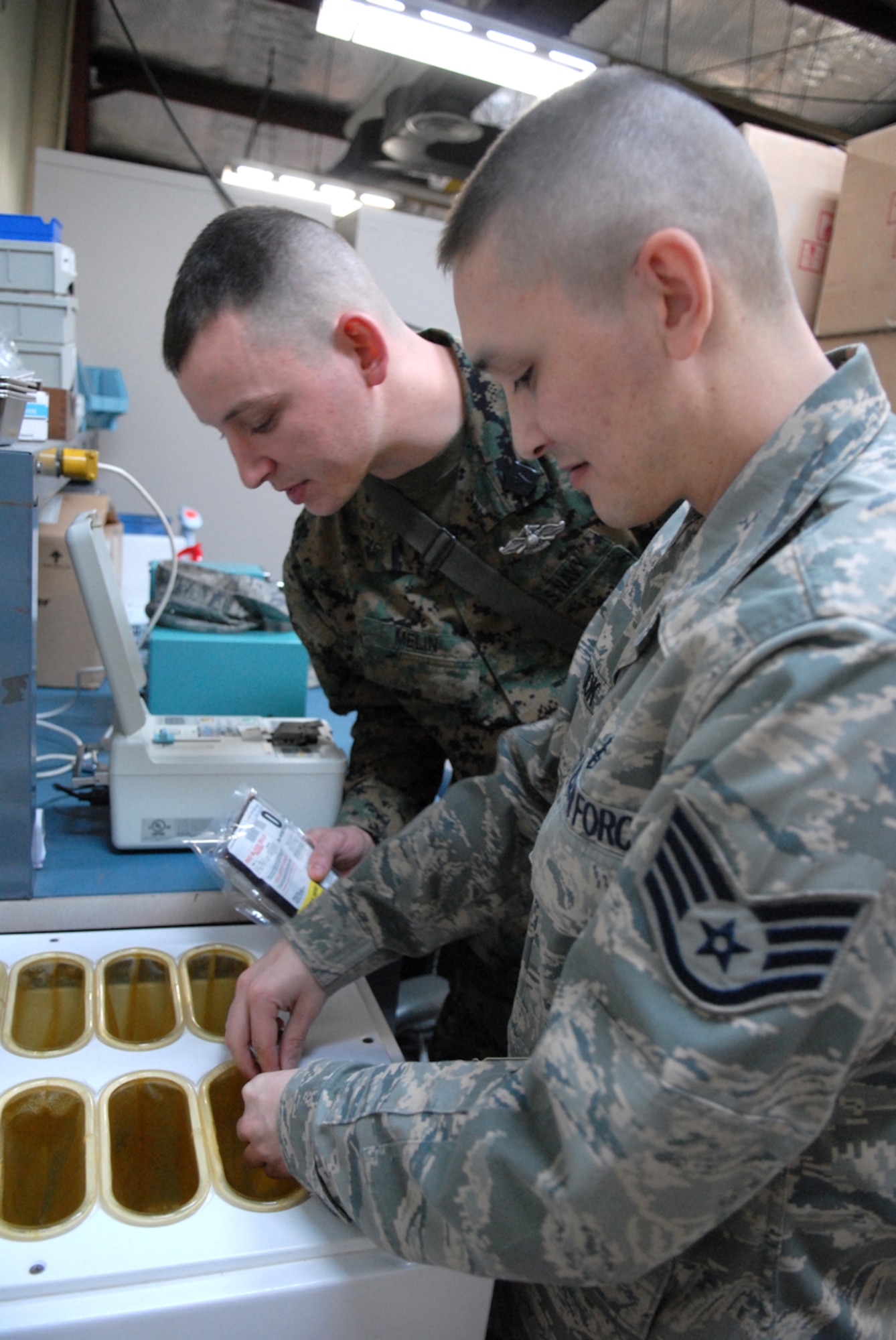 Navy Hospital Corpsman 2nd Class Brian Melin, Marine Wing Support Squadron 171 and Staff Sgt. James Cook, 8th Medical Support Squadron conduct joint training at Kunsan Air Base, Republic of Korea, March 11, 2009. HM2 Melin and Sergeant Cook are training on converting frozen blood to usuable blood for patient care. (US Air Force Photo By: Senior Airman Angela Ruiz)(Released by:8th Fighter Wing, Public Affairs Office,