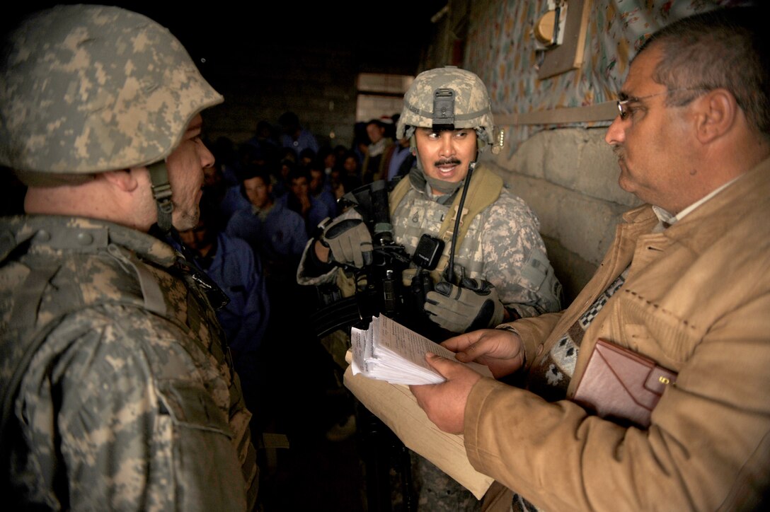 U.S. Army Staff Sgt. Darius Libre, center, 361st Tactical Psychological Operations Company, and Nick, left, an interpreter, ask an Iraqi instructor questions while visiting a Civil Service Corps site to check on the progress of training in Nimrud, Iraq, March 5, 2009. The corps is an Iraqi-funded effort for an "on the job" training program to provide military-aged males trade skills that will provide employment opportunities and will give the community services not readily available.