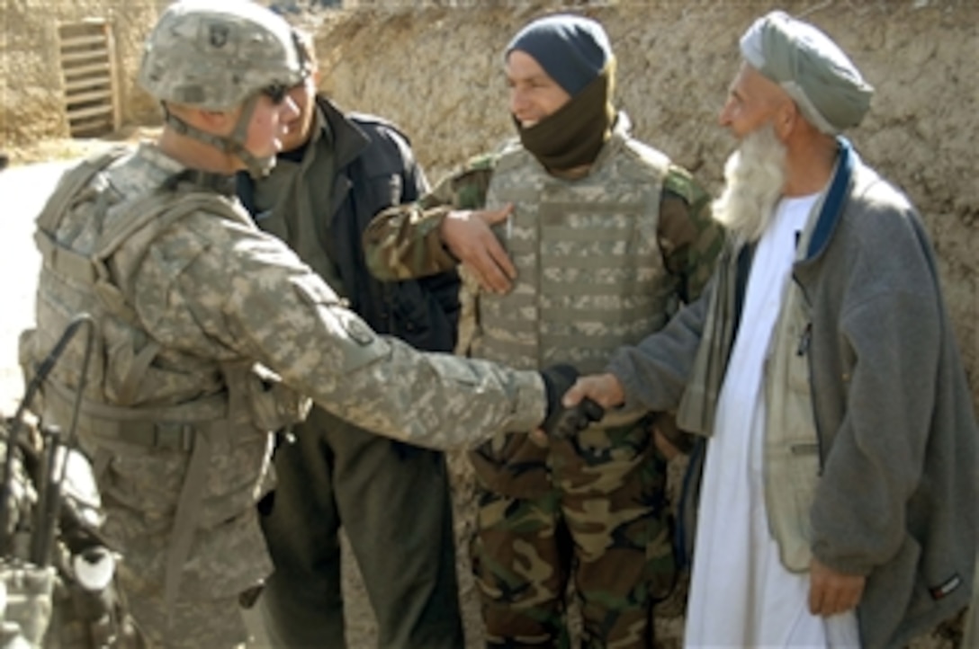 U.S. Army Staff Sgt. James E. Welsh, of Personnel Security Detail, 1st Platoon, Alpha Company, 101st Airborne Division, shakes hands with a civilian in Bagram, Afghanistan, on March 10, 2009.  