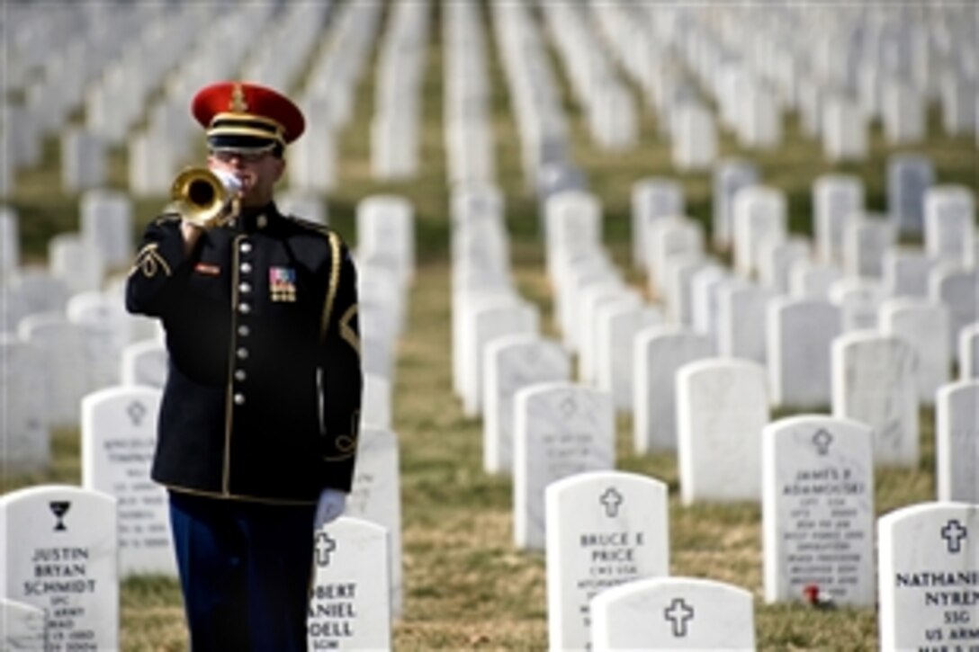 A lone U.S. Army bugler plays taps at the conclusion of the First Annual Remembrance Ceremony in Dedication to Fallen Military Medical Personnel at Arlington National Cemetery,  March 11, 2009.