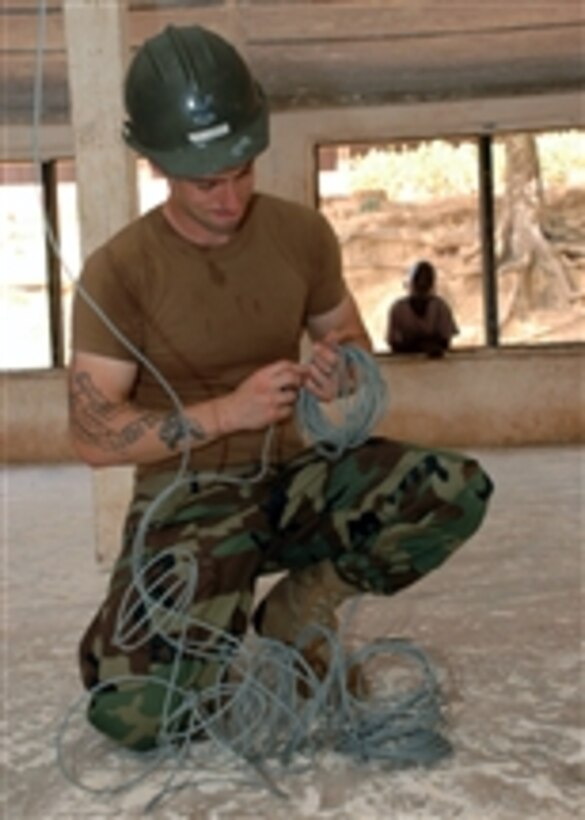 U.S. Navy Petty Officer 2nd Class Joseph Tabor, assigned to Naval Mobile Construction Battalion 11, installs new wiring for lights during a refurbishment project at the Naval Base Basic School in Takoradi, Ghana, during an Africa Partnership Station visit to Ghana by the amphibious transport dock ship USS Nashville (LPD 13) on March 2, 2009.  A team of Seabees from Naval Mobile Construction Battalion 11 is embarked aboard the Nashville as part of Africa Partnership Station, an international initiative developed by Naval Forces Africa that works with U.S. and international partners to enhance maritime safety and security for the African continent.  