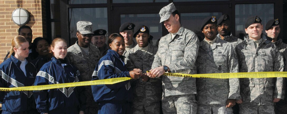 Base leaders assist members of the Andrews community cut the ribbon for the opening of the new Visitor Control Center March 3. The new, larger VCC includes four more processing sections, helping desk personnel process twice the amount of people than in the old building in the same amount of time. (U.S. Air Force photo/ Staff Sgt. Melissa Stonecipher)