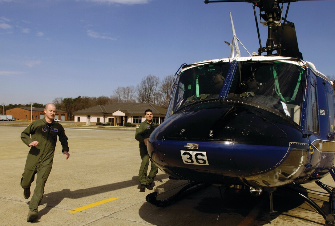 1st Lt. Matt Finnegan, left, and Maj. Brian McGraw, right, 1st Helicopter Squadron pilots, run to a UH-1Huey during a scramble exercise on the Andrews flightline Thursday. The pilots practice getting the helicopters airborne in a short period of time after receiving an alert. 1 HS provides contingency support in the National Capital Region. (U.S. Air Force photo/ Senior Airman Renae Kleckner)