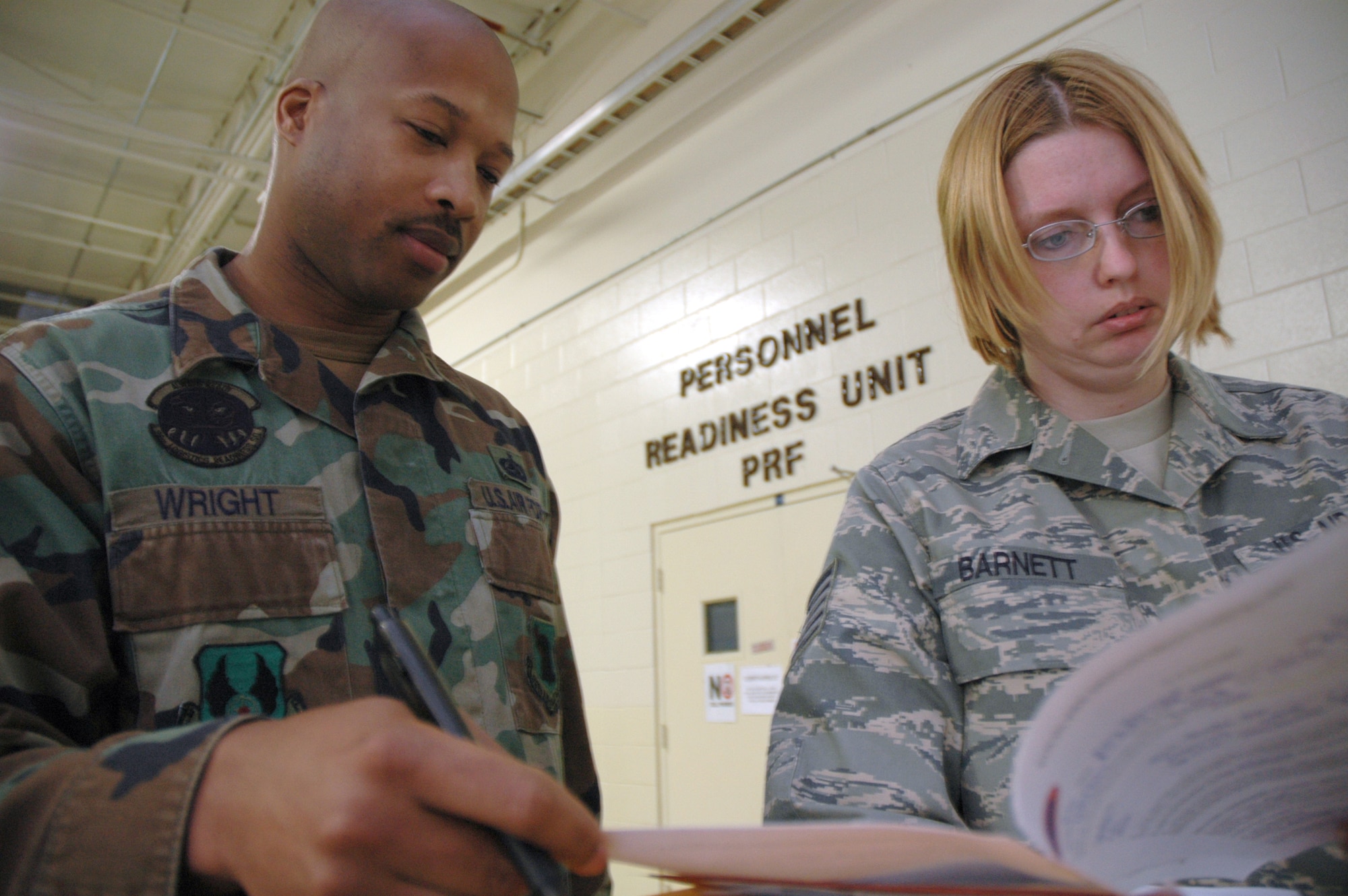 EGLIN AIR FORCE BASE, Fla. -- Tech Sgt. Kedrick wright, 96th Logistics Readiness Squadron unit deployment manager, completes paperwork for Tech. Sgt. Amy Barnett. Sergeant Barnett is preparing to deploy in support of Operation Iraqi Freedom. Unit deployment managers bear the brunt of making sure Airmen are ready to deploy. UDMs monitor the readiness of each unit member and interface with the personnel readiness function. (U.S. Air Force photo/ Airman Anthony Jennings)