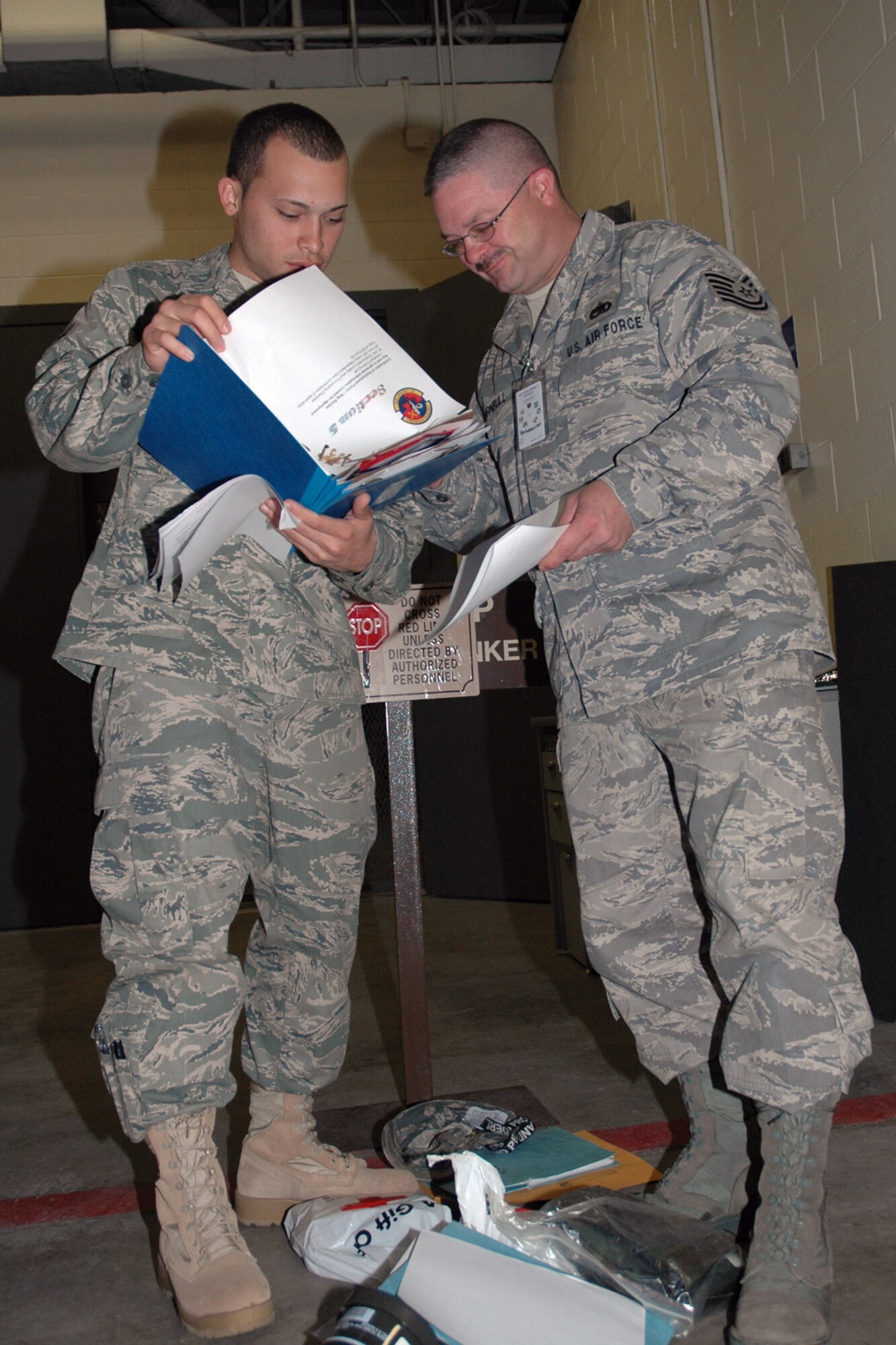 EGLIN AIR FORCE BASE, Fla. -- Tech. Sgt. Steven Turnbull, 46th Aircraft Maintenance Squadron, unit deployment manager, completes paperwork for Airmen 1st Class Jean Vega. Airman Vega is preparing to deploy in support of Operation Iraqi Freedom. Unit deployment managers bear the brunt of making sure Airmen are ready to deploy. UDMs monitor the readiness of each unit member and interface with the personnel readiness function. (U.S. Air Force photo/ Airman Anthony Jennings)