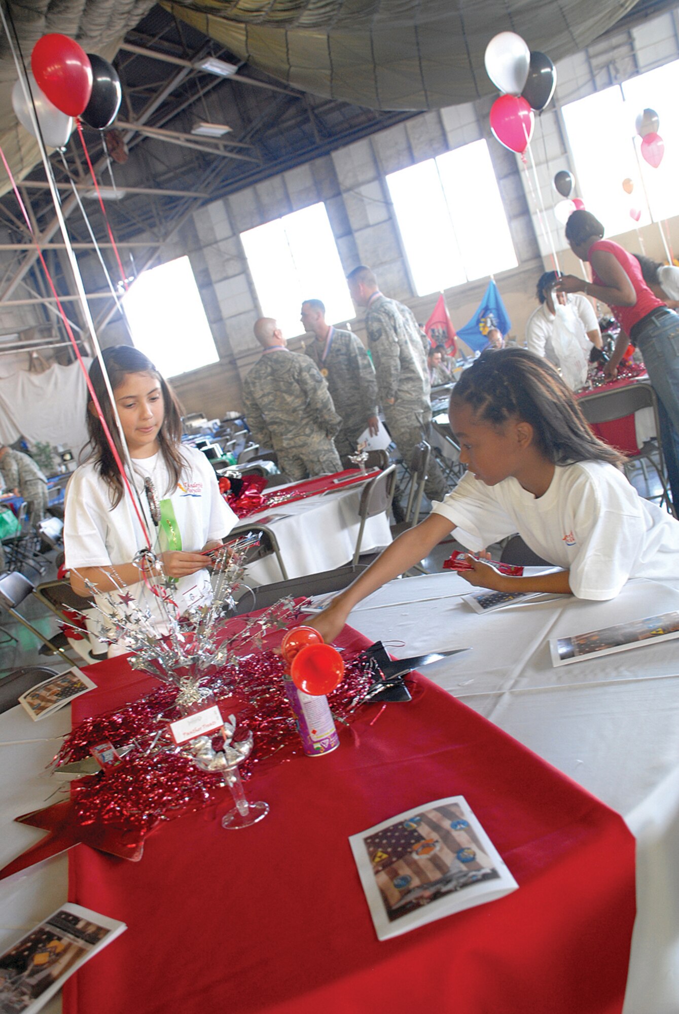 Valentina Arroyo and Maya Evans, both 10, help decorate tables in Hangar 913 before the banquet. (U.S. Air Force photo/ Airman 1st Class Tracie Forte)