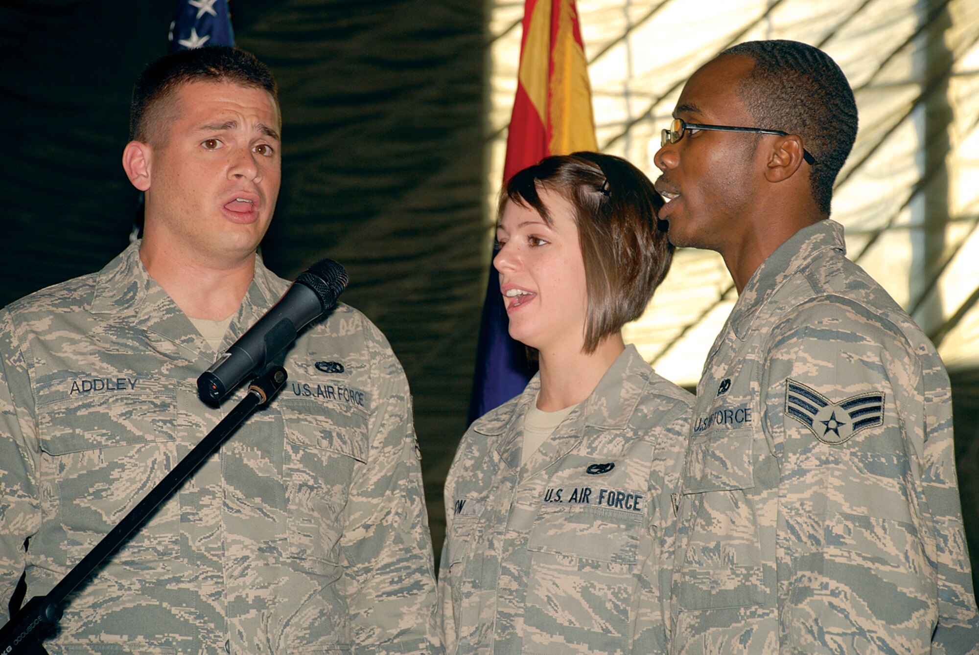 Senior Airman Nathaniel Addley, Airman 1st Class Kelsey Dion and Senior Airman Joshua Lane, all from the 309th Aircraft Maintenance Unit, sing the National Anthem. (U.S. Air Force photo/ Airman 1st Class Tracie Forte)
