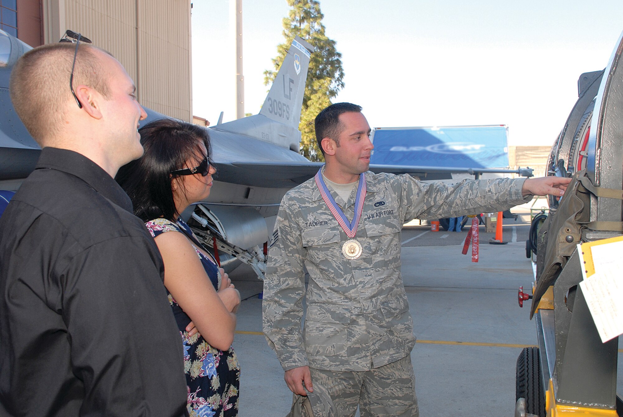 Staff Sgt. Robert Taupier, 756th Aircraft Maintenance Squadron, explains the components of an aircraft to friends and family before the start of the Maintenance Professional of the Year banquet. (U.S. Air Force photo/ Airman 1st Class Tracie Forte)