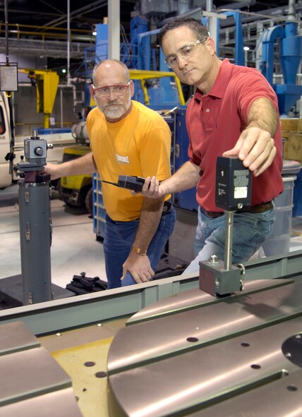 When a millionth of an inch mi-alignment can cause the creation of unusable parts, a special laser is needed to keep production flowing. Walt Grimes, back, and Robert Hague use the laser annually or when requested to test equipment like a multi-axis machine in Bldg. 3001.  (Air Force photo/Margo Wright)