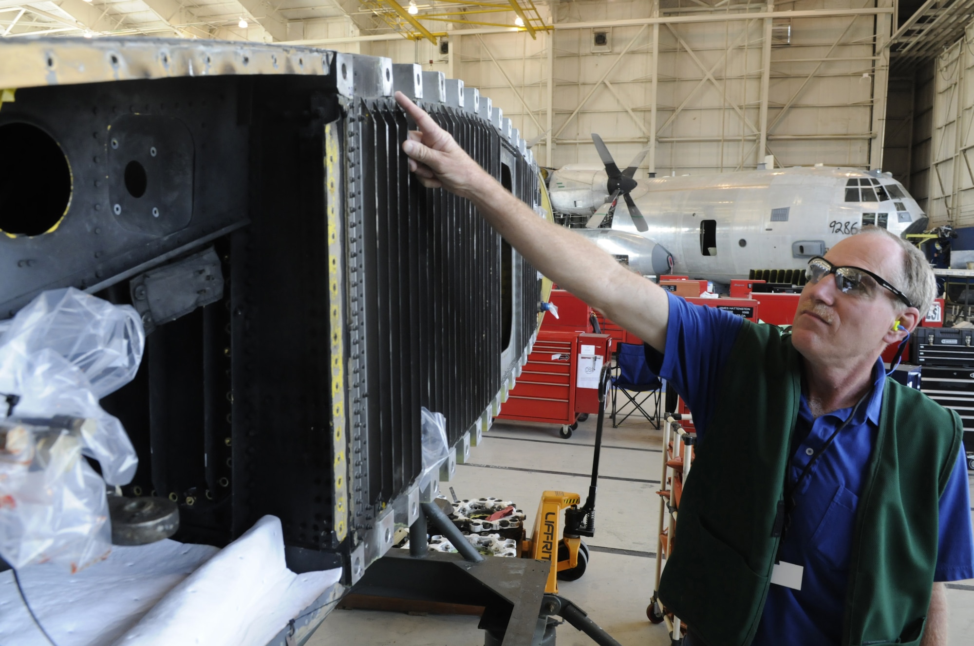 Jud Fiebiger, 560th AMXS Chief C-130 Production swing shift superintendent, points out the upper wing rainbow fitting, where Robins workers found cracked nuts on C-130H tail # 86 0418. U. S. Air Force photo by Sue Sapp
