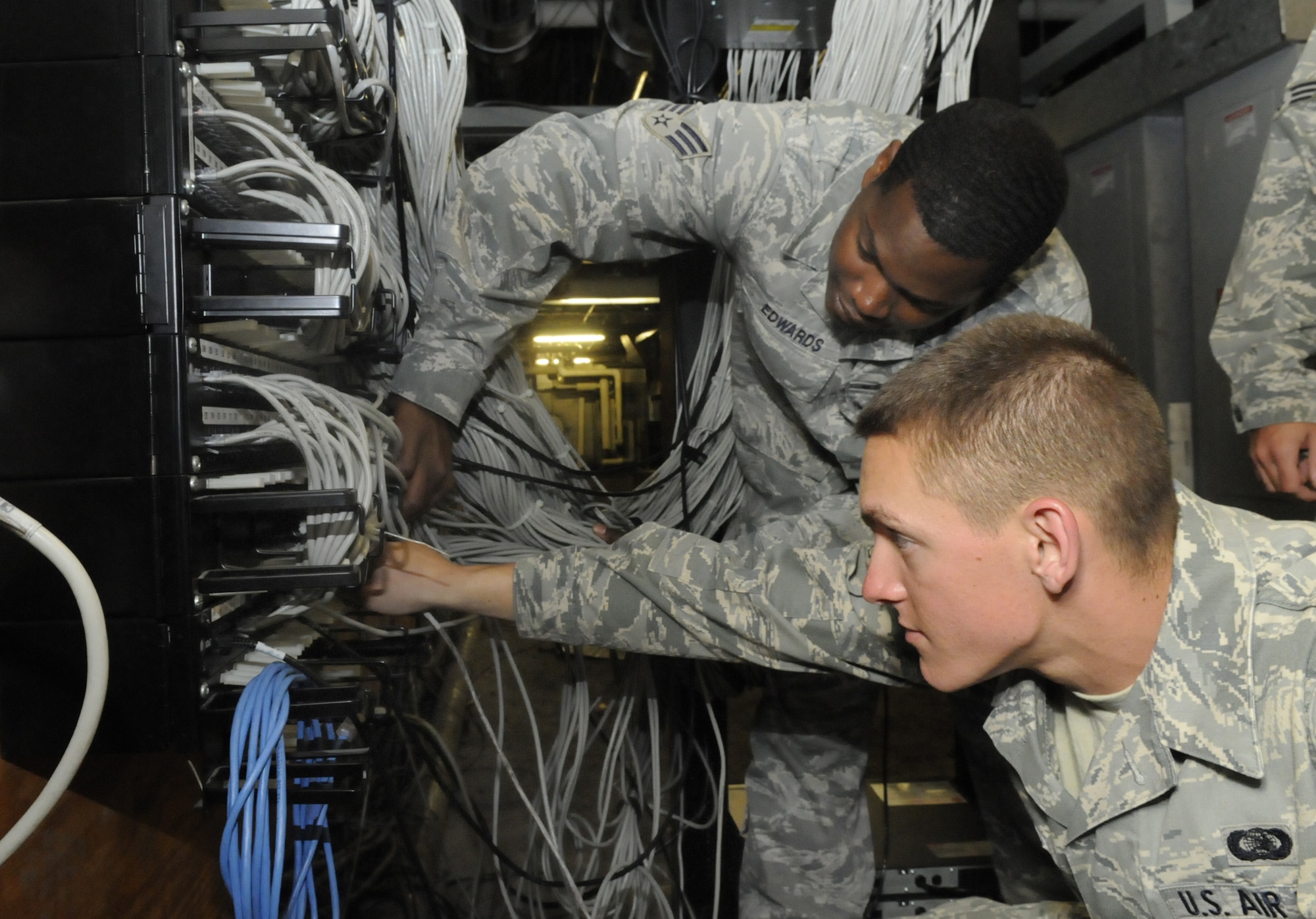 Airman Nicholas Johns, right,  and Senior Airman Eddie Edwards, 78th Communications Squadron network infrastructure technicians, upgrade network switches and make network connection more efficient in Building 300. U. S. Air Force photo by Sue Sapp