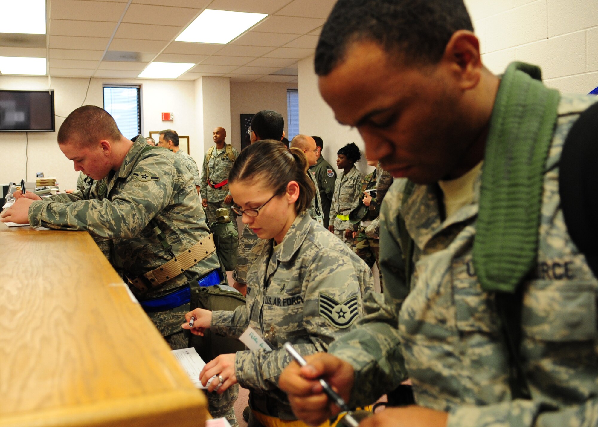 Airman Michael Soloman, 4th Component Maintenance Squadron, Staff Sgt. Valarie Risley, 4th Aerospace Medical and Dental Squadron, and other Airmen from Seymour Johnson Air Force Base, N.C., review personal deployment documents  during a training exercise March 12, 2009. The operational readiness exercise is part of a series of phase-one exercises, which will culminate in an Air Combat Command inspection in the summer of 2010. (U.S. Air Force photo by Airman 1st Class Rae A. Perry)