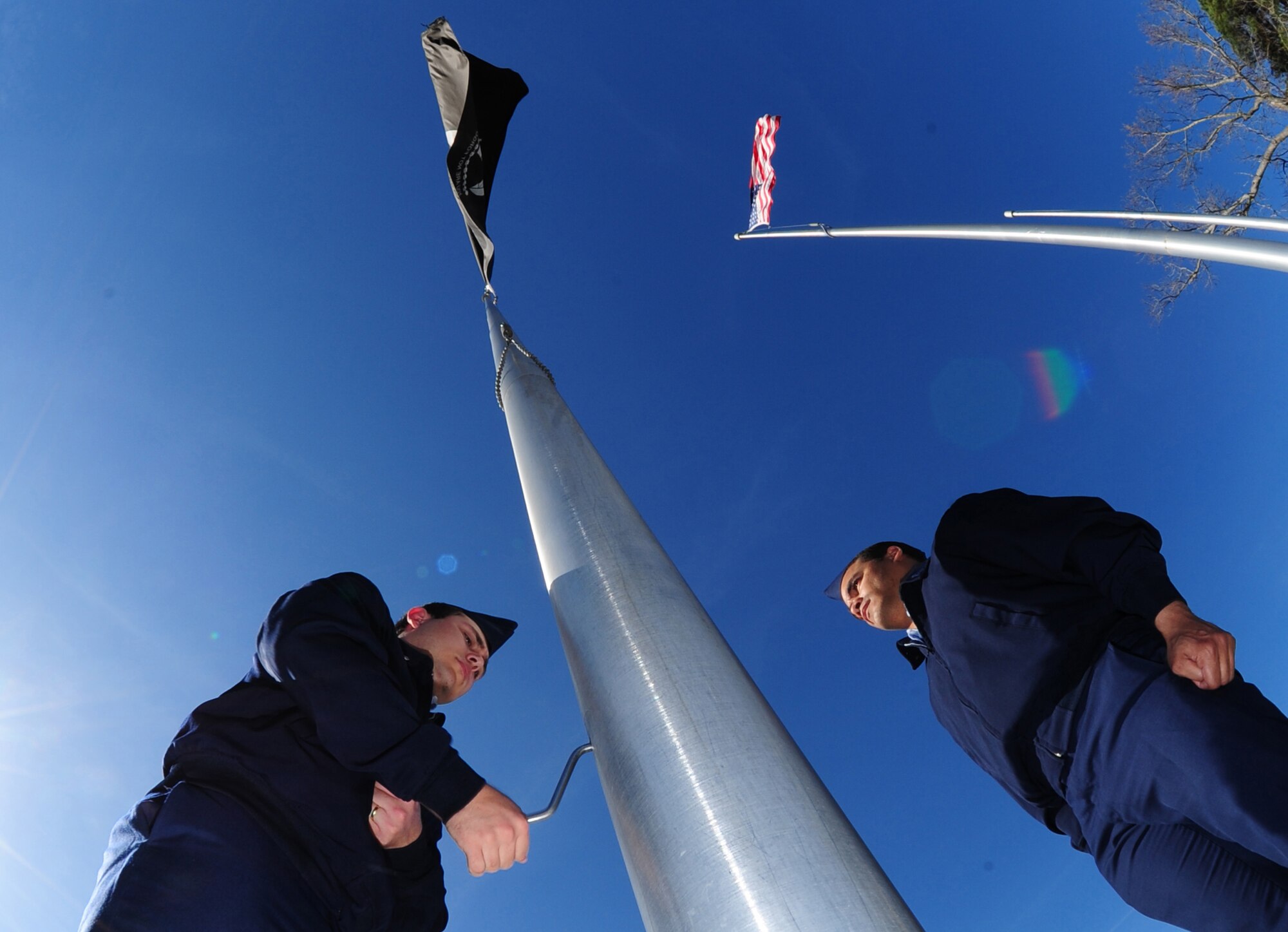 Airmen 1st Class Joseph Williams and Carlos Gomez, 4th Fighter Wing Base Honor Guard, lower the Prisoners of War/ Missing in Action flag during a retreat ceremony at Seymour Johnson Air Force Base, N.C., March 9, 2009. During the retreat ceremony, Airmen from the Honor guard lower the North Carolina, POW/MIA and the U.S. flag. Fourth Security Forces Squadron Airmen raise the flags every morning during reveille.  (U.S. Air Force photo by Airman 1st Class Rae A. Perry)