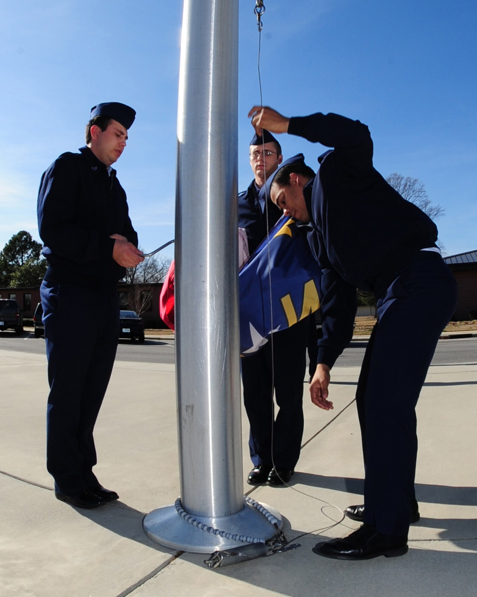 Airmen 1st Class Joseph Williams and Carlos Gomez and Senior Airman Erving Perkins, 4th Fighter Wing Base Honor Guard, gather the North Carolina state flag from a wing flag pole during a retreat ceremony at Seymour Johnson Air Force Base, N.C. March 9, 2009.  The state flag is the first flag lowered during the retreat ceremony. Airmen perform a retreat ceremony every day, weather permitting. (U.S. Air Force Photo by Airman 1st Class Rae A. Perry)