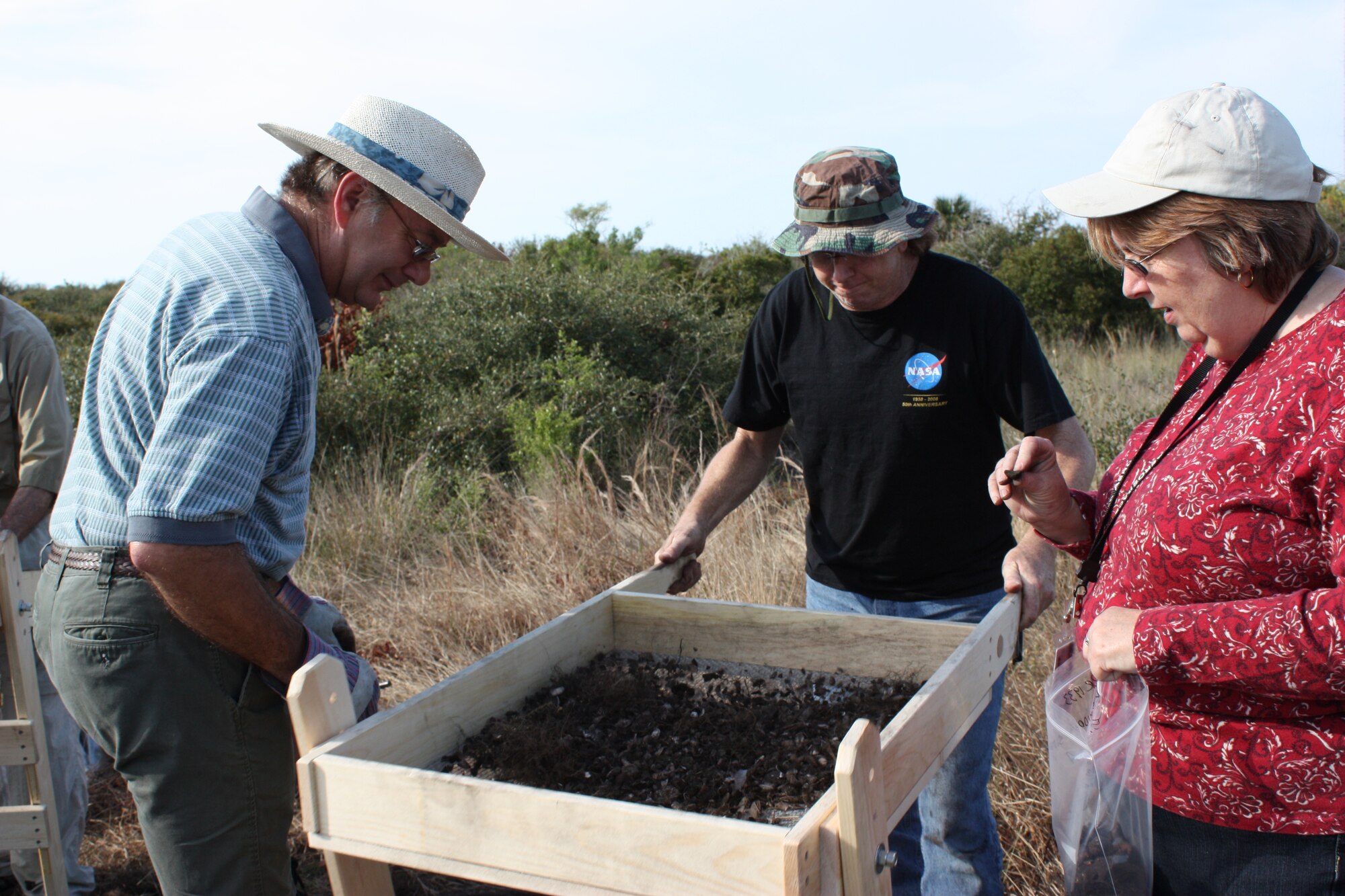 (left to right) Dale Hawkins, Timothy Kozusko and Elaine Williams sift through dirt and stones for artifacts at the Little Midden archeological site at Cape Canaveral Feb. 27. (U.S. Air Force photo/Airman 1st Class David Dobrydney)